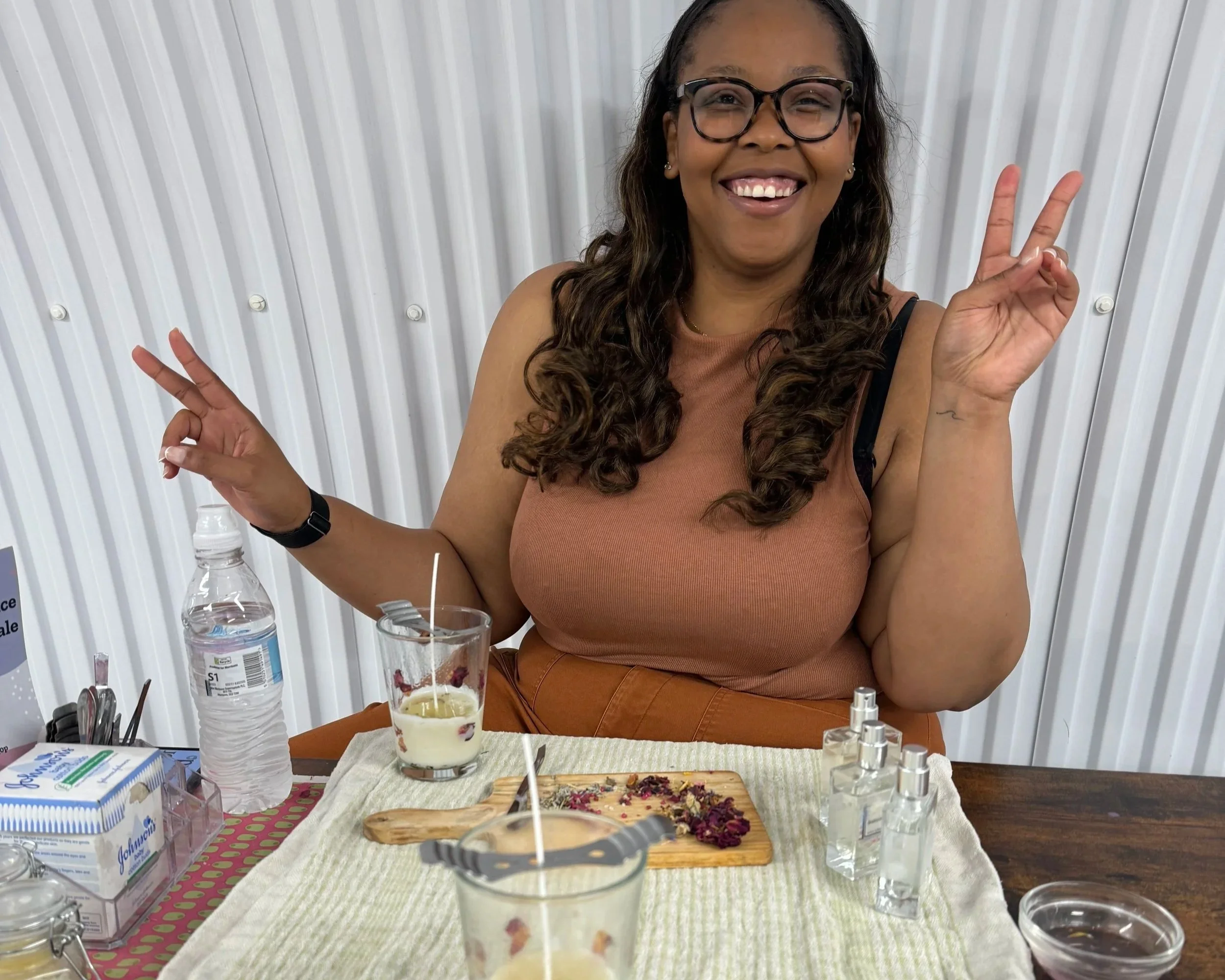 Three black women hold their pottery bowls to the camera smiling.