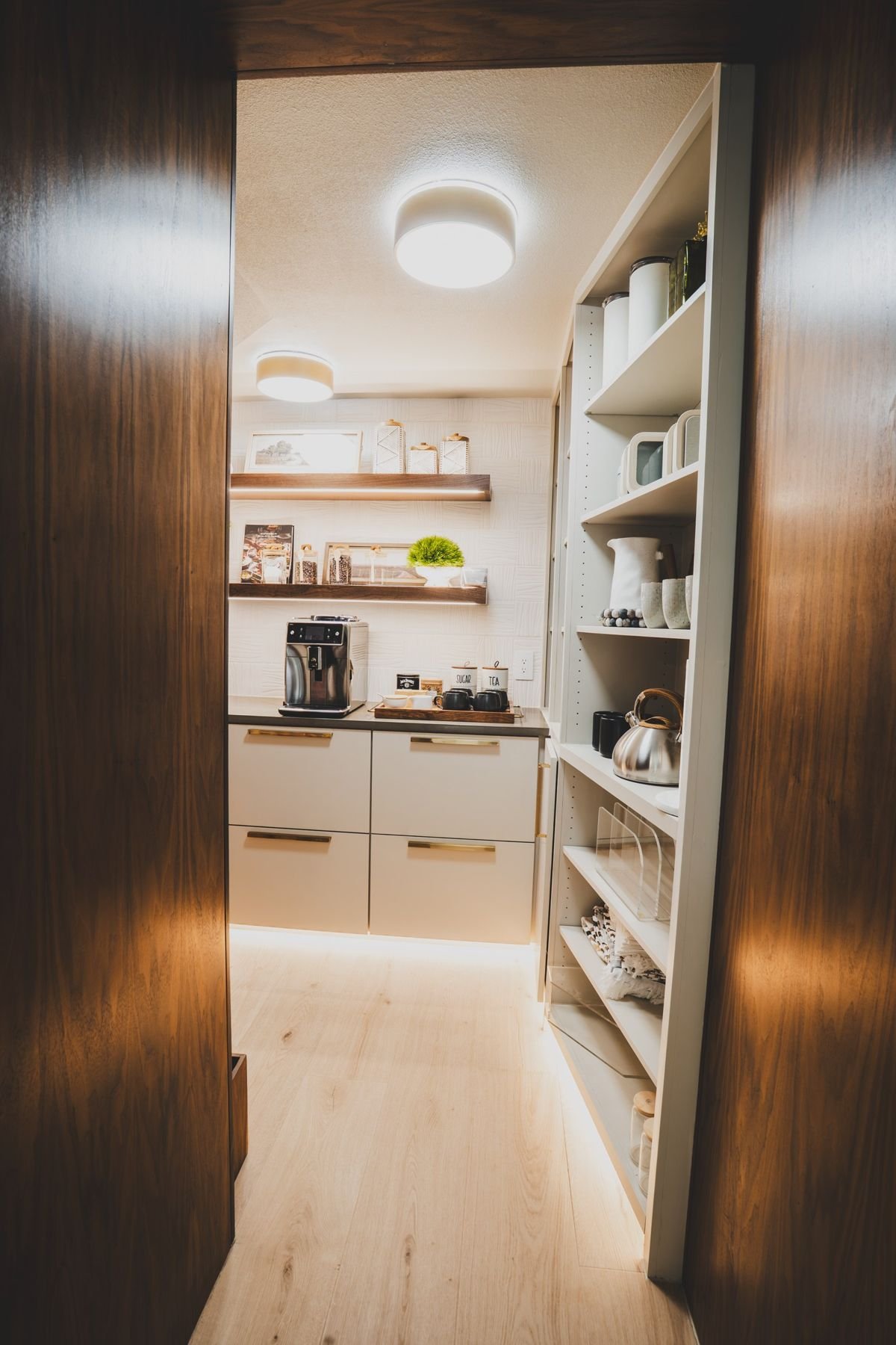 Coffee and tea pantry with shelves and floor-level lighting