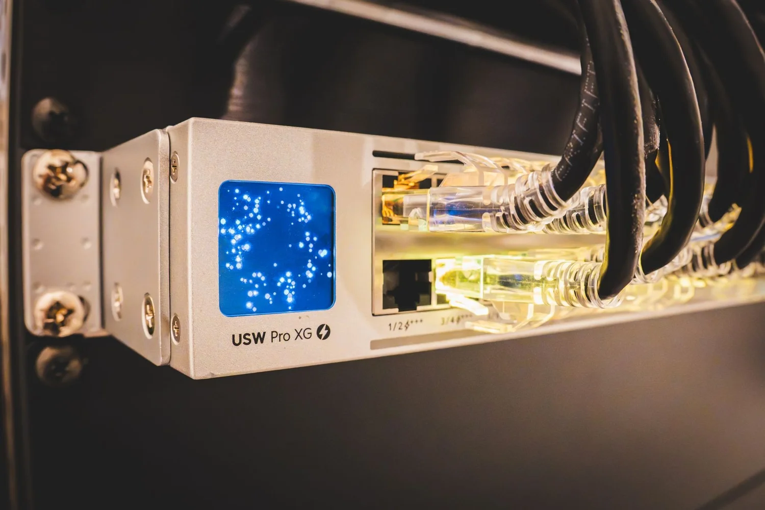 Network switch with a lit port indicator and cables in a rack
