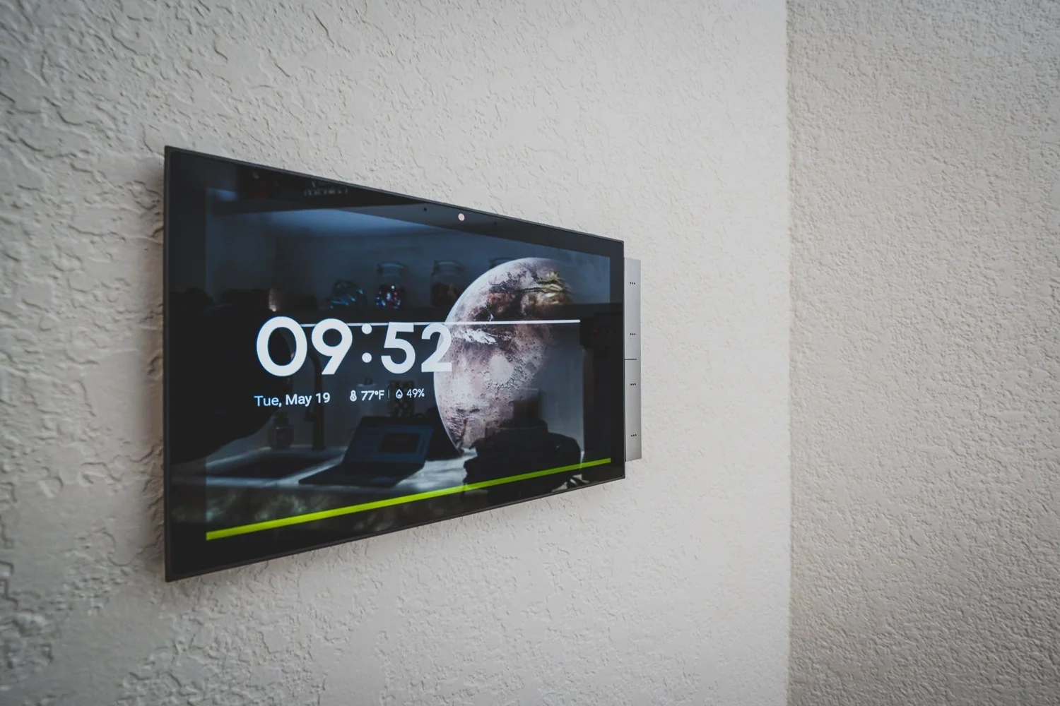 Wall-mounted touchscreen showing a clock and weather