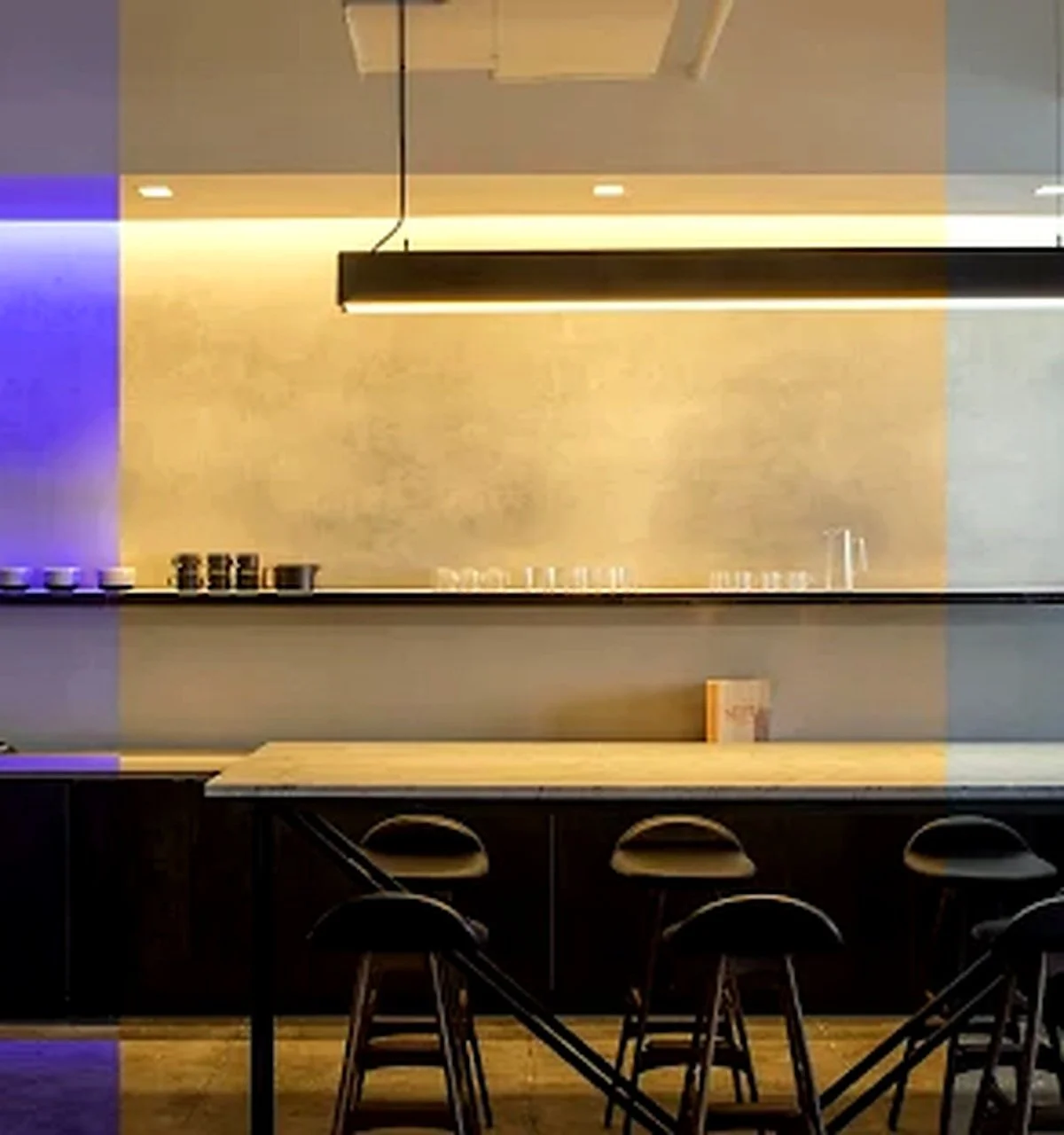 Modern cafe or restaurant interior with a counter, bar stools, and a minimalist design.