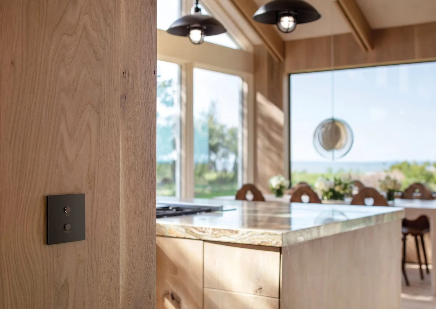 Lutron Alisse keypad on a wood wall near a kitchen island