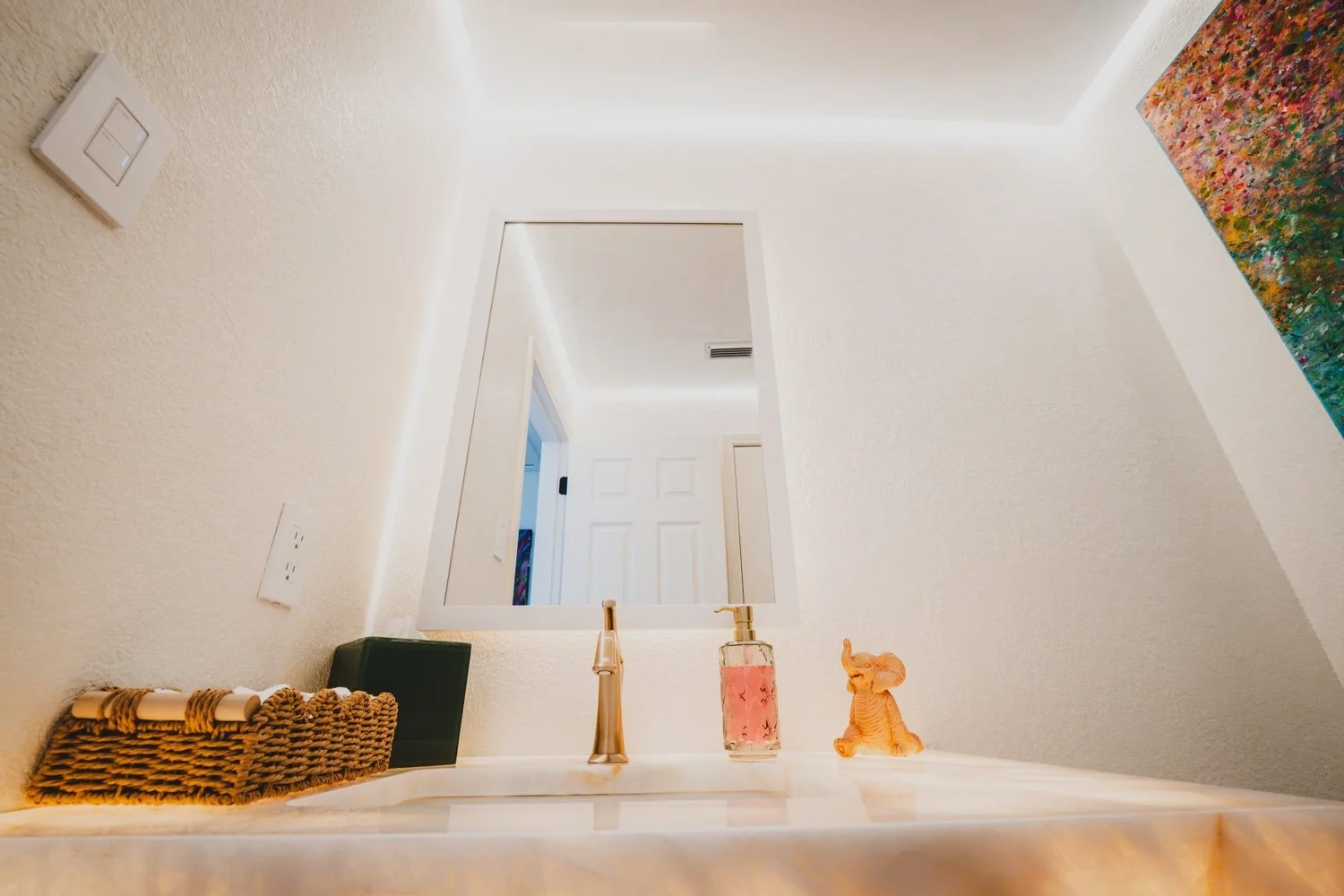 Cove lighting washing the walls of a showroom powder room