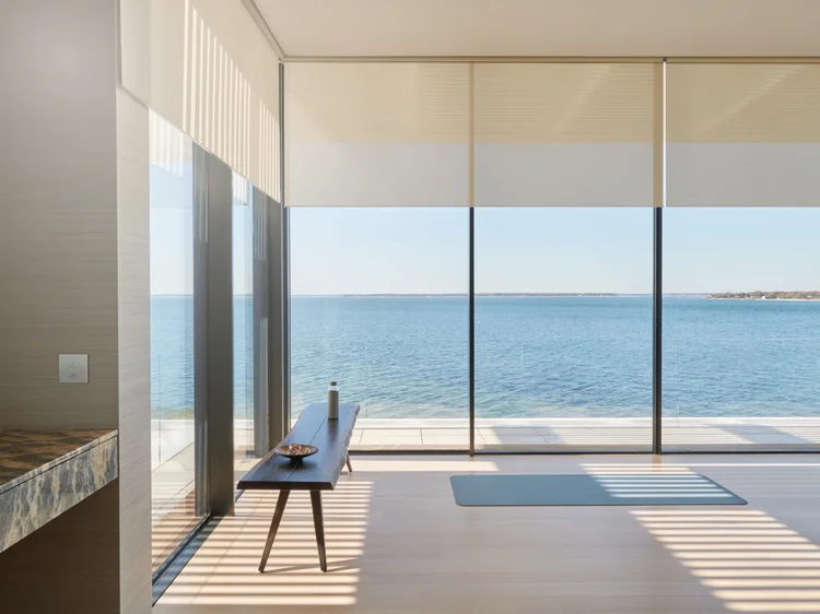 Waterfront room with glass walls (Sag Harbor Residence): Lutron motorized roller shades