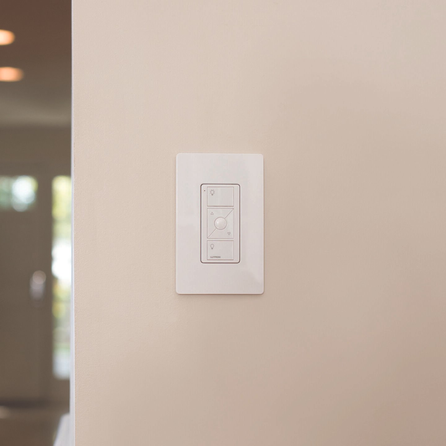 Light switch panel on a beige wall with multiple controls.