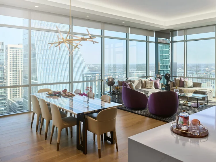 High-rise dining and lounge area (Seaholm Penthouse, Austin, TX): QS roller shades, Lumaris cove lighting, Ketra fixtures and HomeWorks QSX