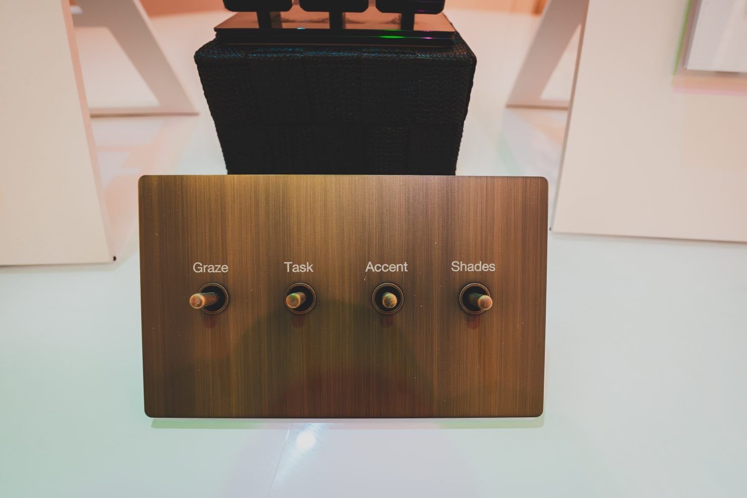 Walnut wall plate with four brass toggle switches