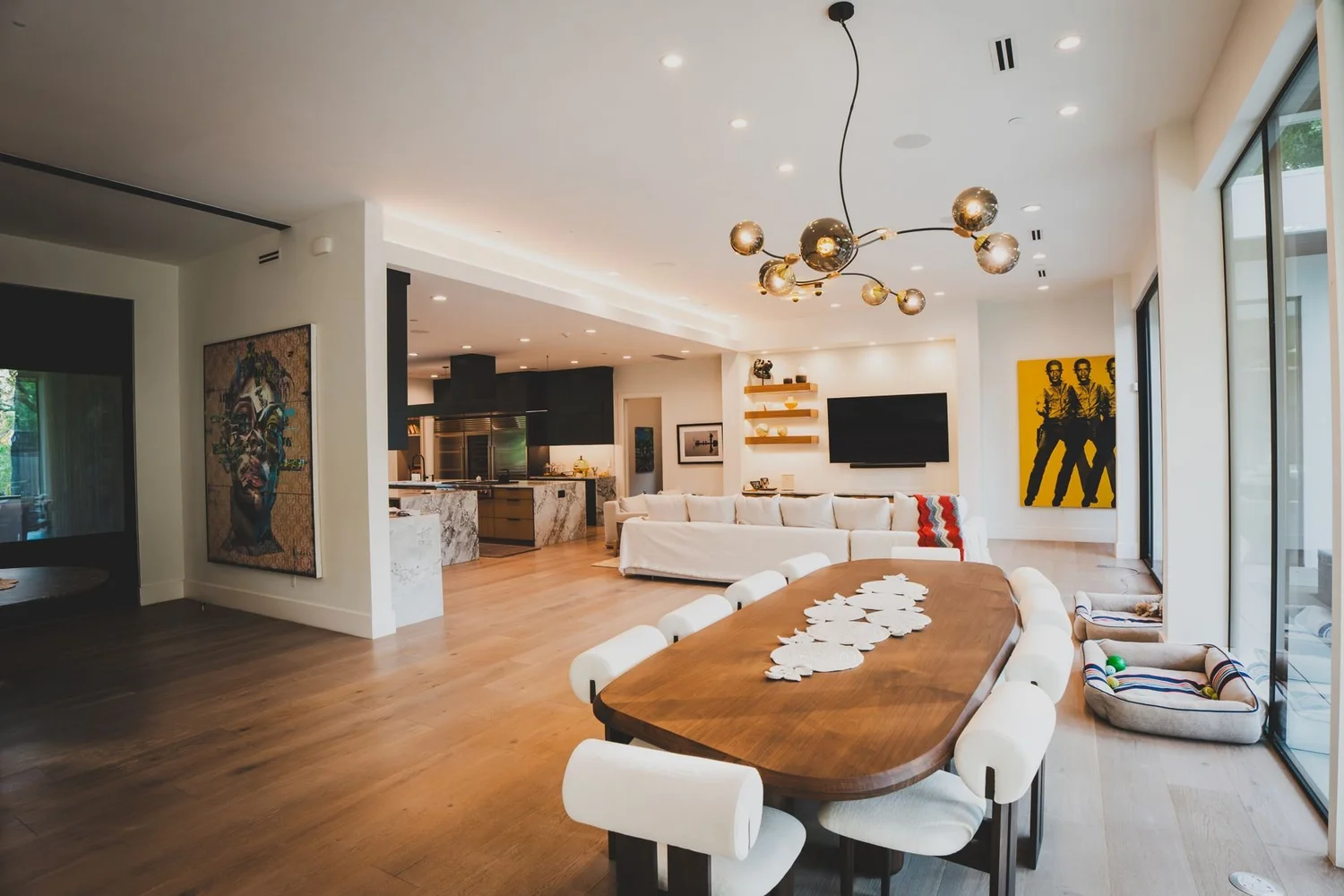 Open-plan great room with dining table, kitchen, and recessed lighting