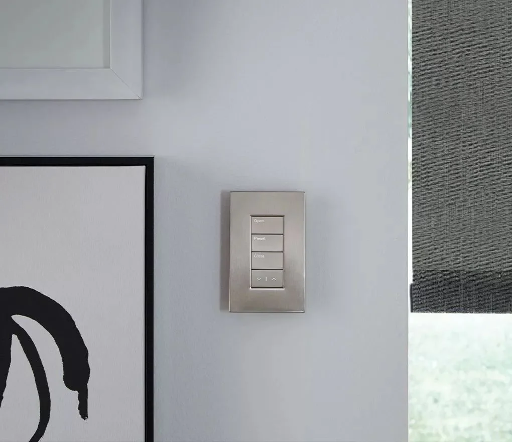 Lutron Palladiom keypad on a white wall beside a shade