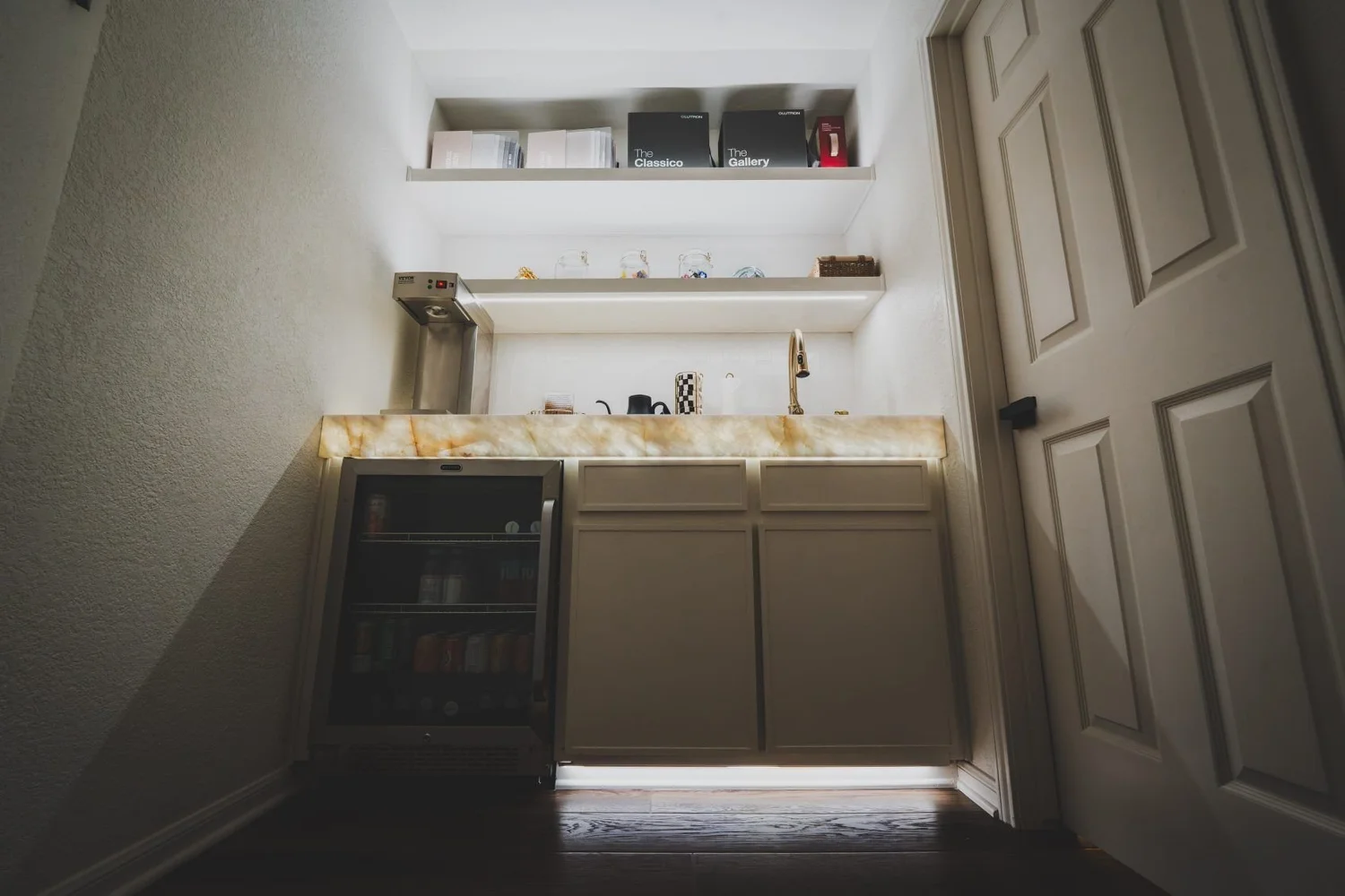 Wet bar with shelf and toe-kick lighting in a bright scene