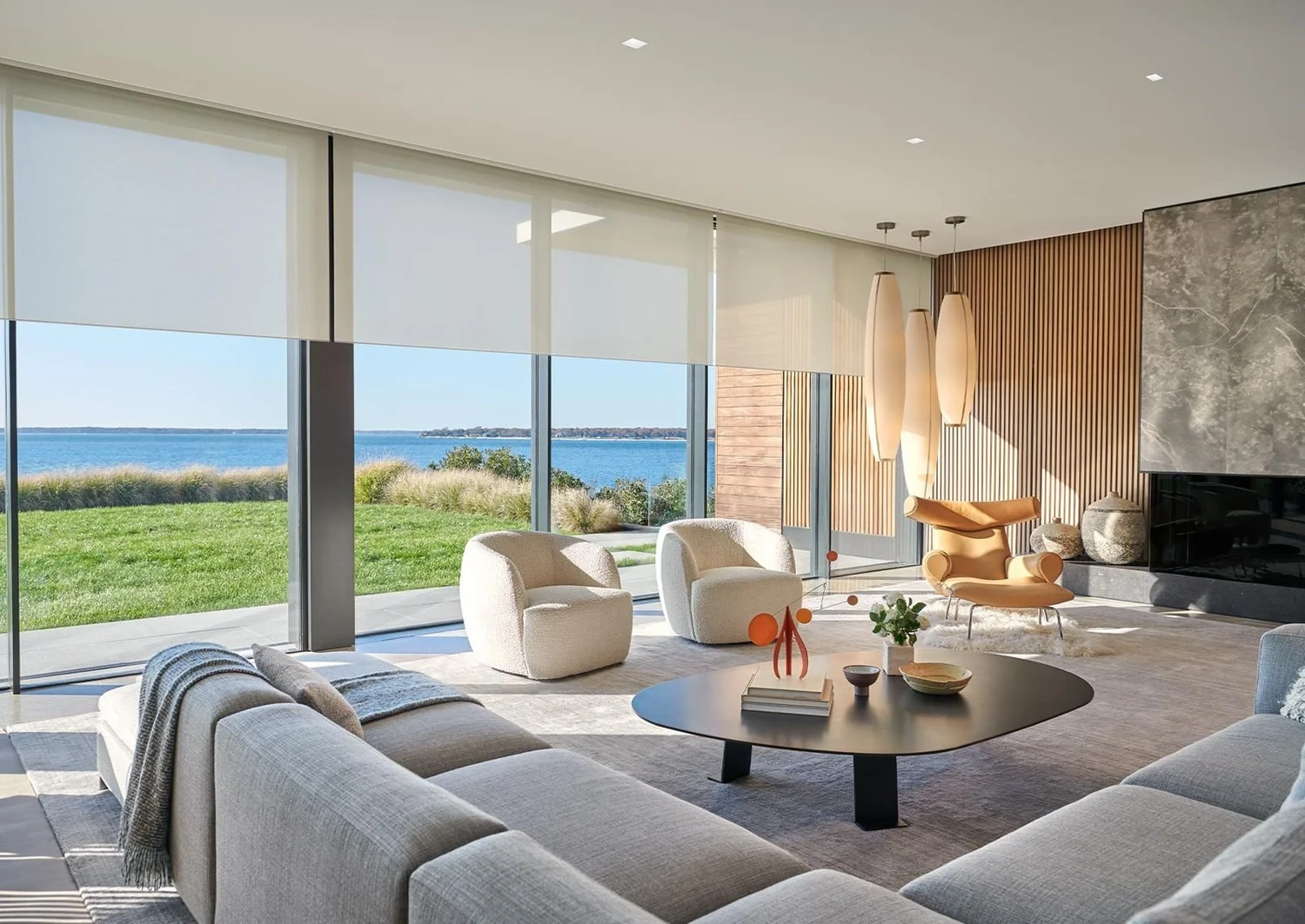 Lutron roller shades lowered across large living room windows