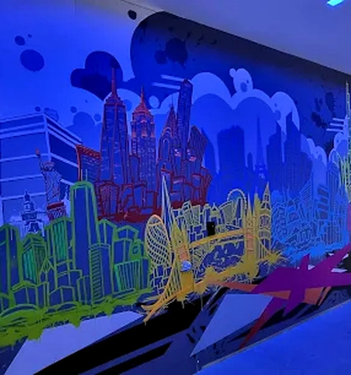 Colorful neon-style illustration of a city skyline with famous landmarks, including the Empire State Building and the Statue of Liberty, set against a dark blue background.