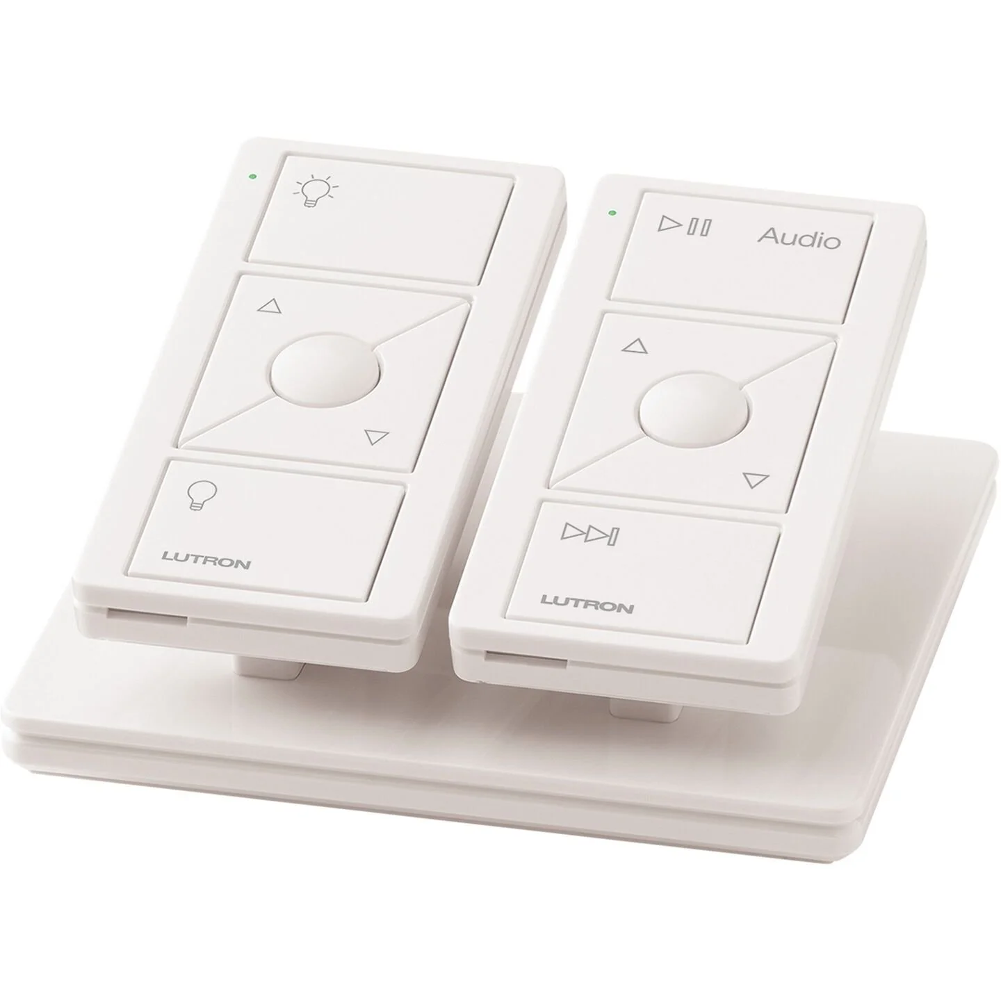 Two white PICO remote controls for a Lutron lighting system, placed on a white pedestal, with multiple buttons for lighting control and audio playback.