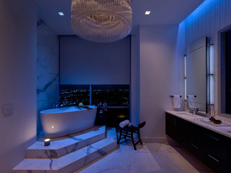 Bathroom with soaking tub and chandelier (Seaholm Penthouse, Austin, TX): Ketra color-changing lighting, Triathlon shades and HomeWorks QSX