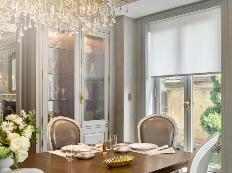 Dining room with crystal chandelier (Ritz Tower Residence, New York, NY): QS roller shades and HomeWorks QSX control