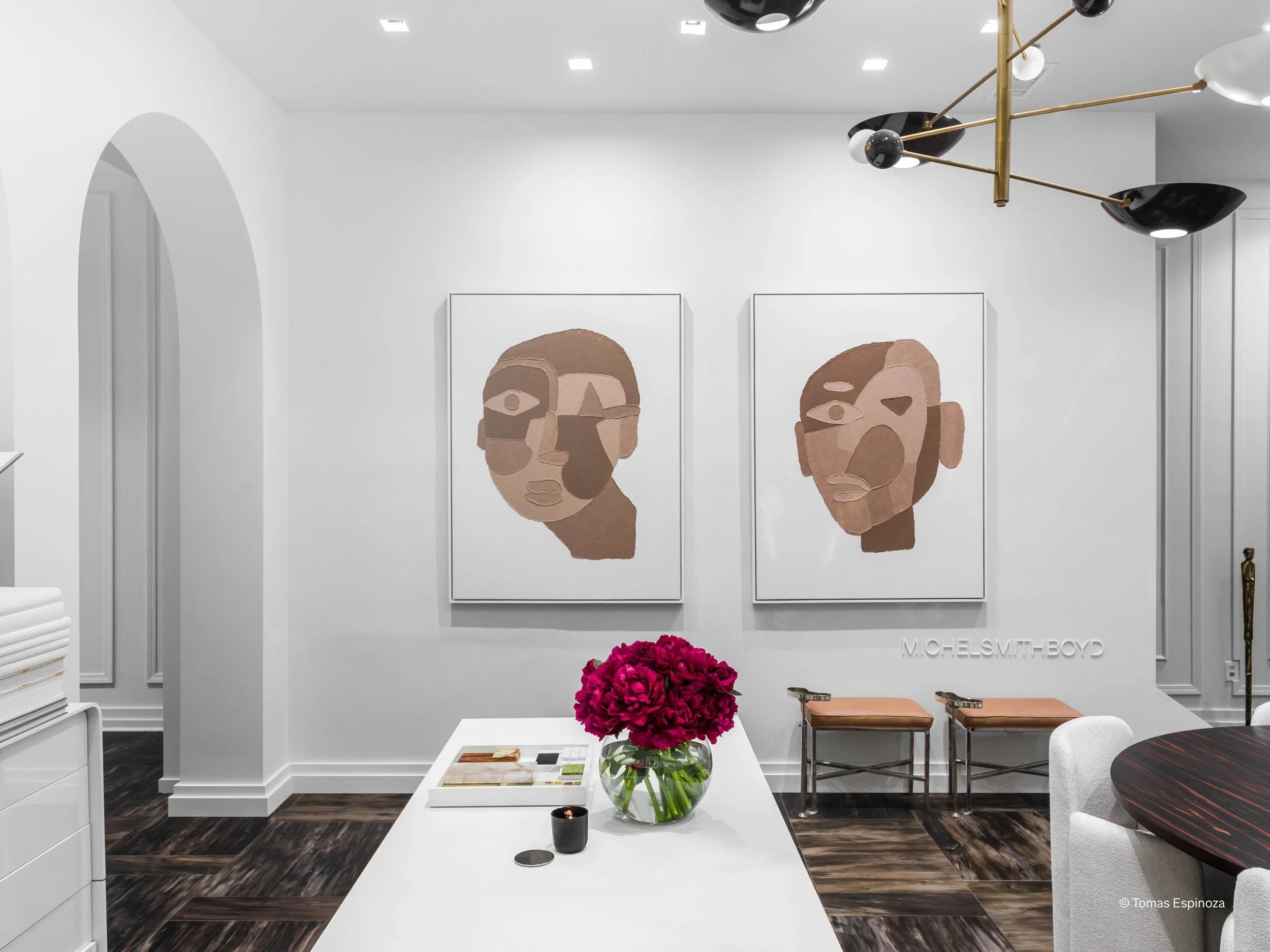 A modern, gallery-like interior with Lutron smart lighting accentuating minimalist design and contemporary artwork. Recessed LED downlights evenly illuminate the crisp white walls, while a modern brass chandelier adds architectural interest and warmt