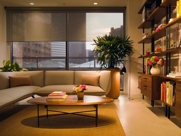 Urban living room with city views: Lutron motorized roller shades and accent lighting