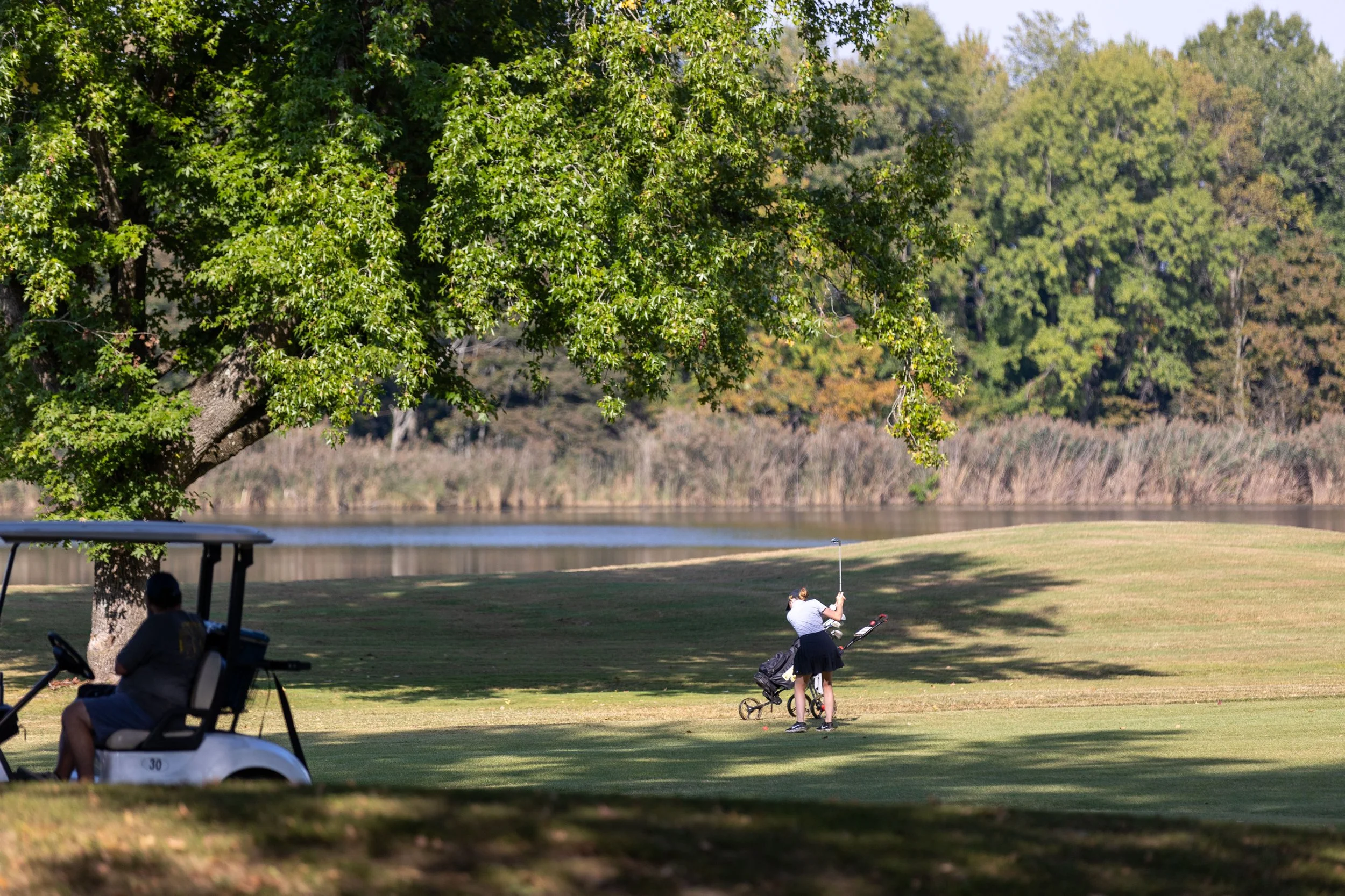 Golfer hitting approach shot near water hazard at FCCC