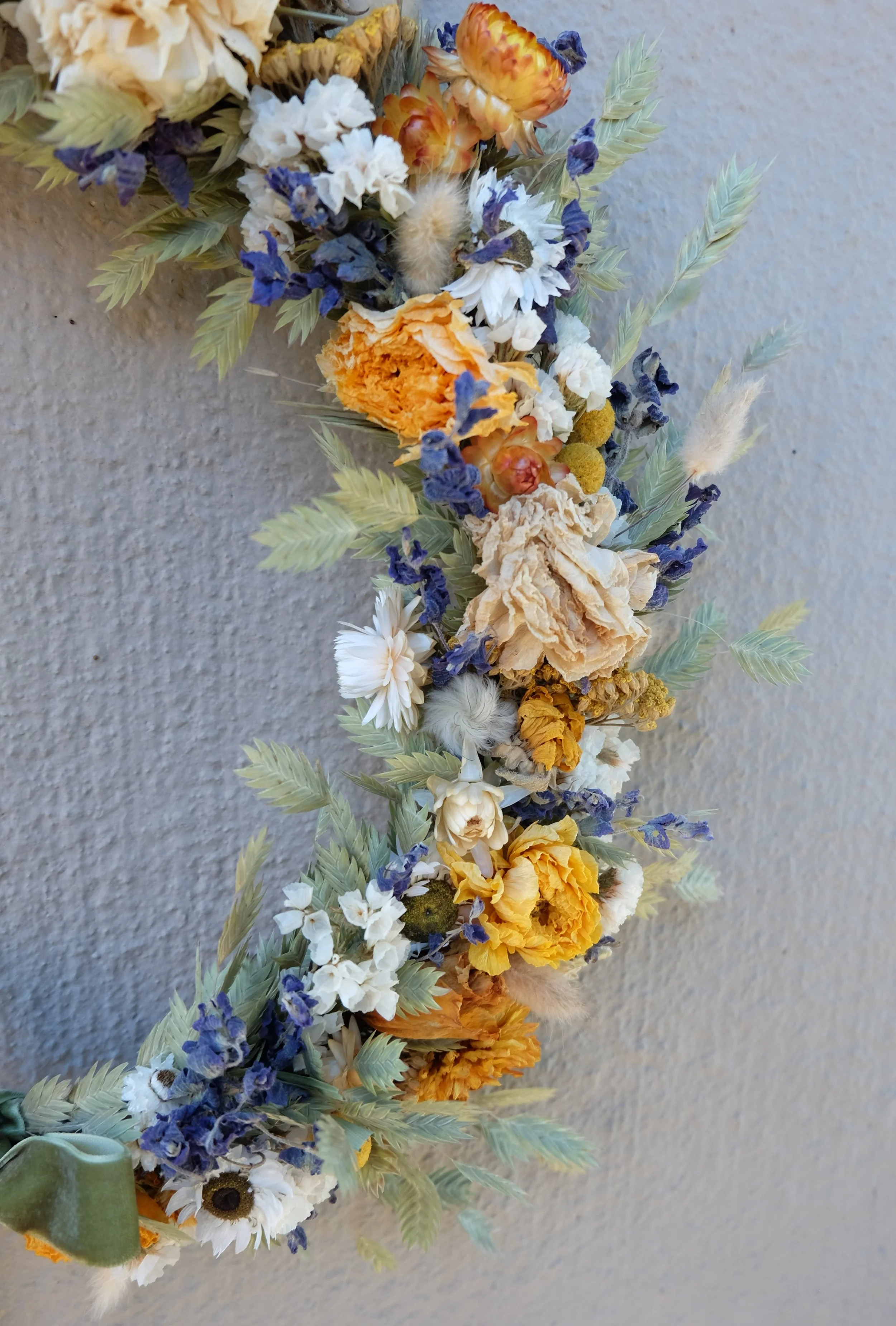 Closeup of dried flower wreath in gold and blue and white