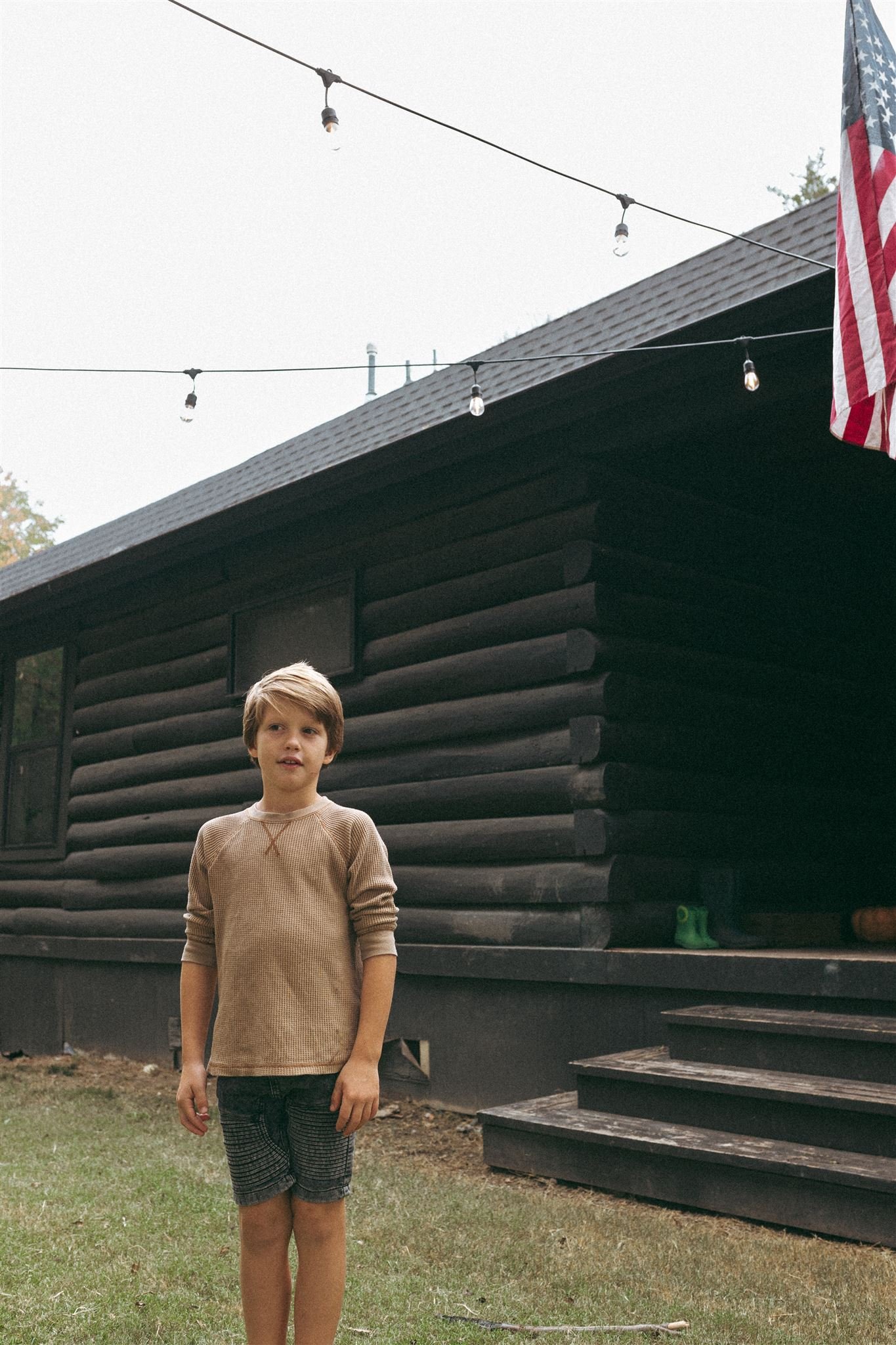  A boy looking at the camera in front of a black house in Allen, Texas 