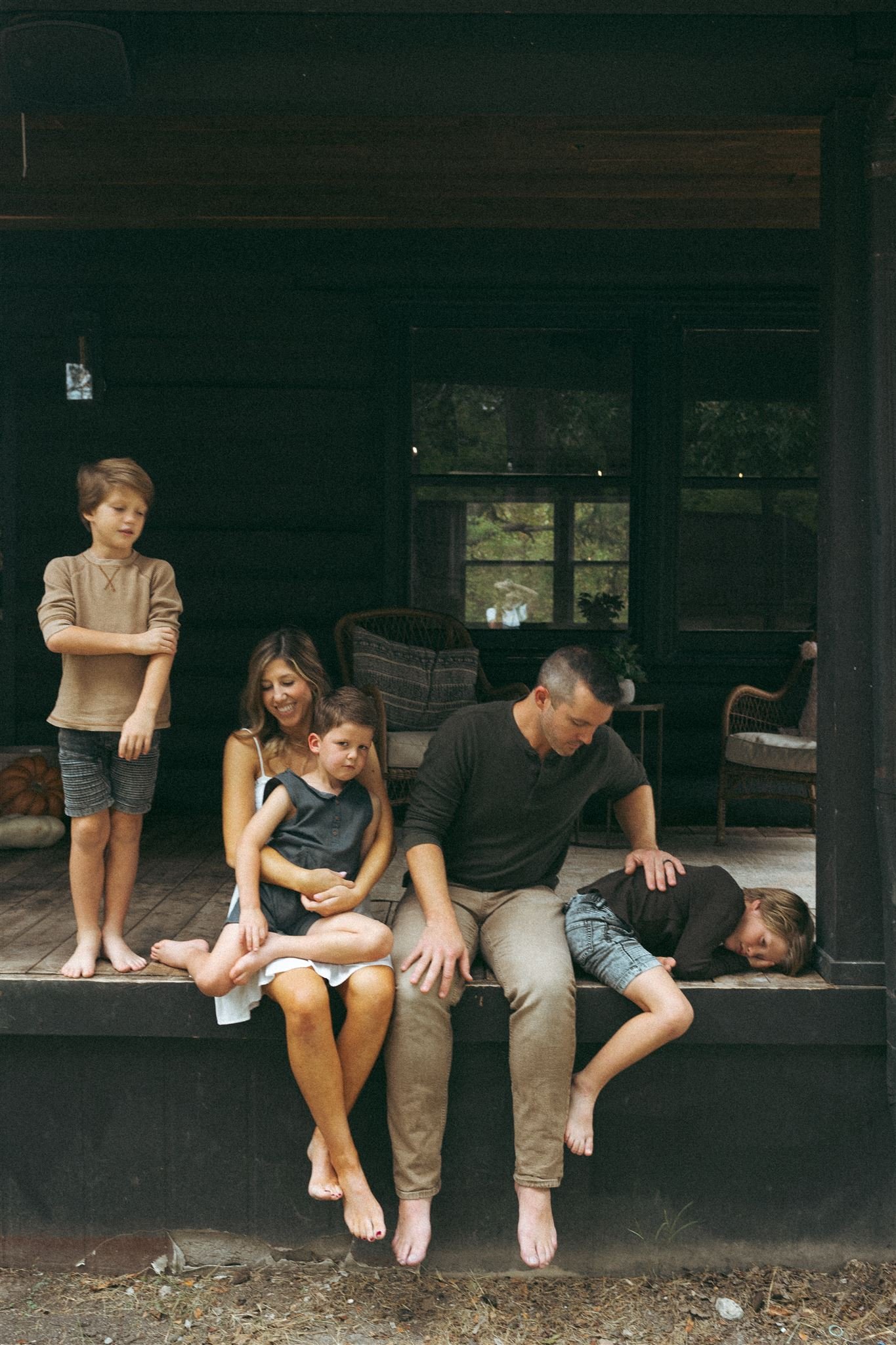 a family sitting on their front porch in Allen, Texas in front of a black house 