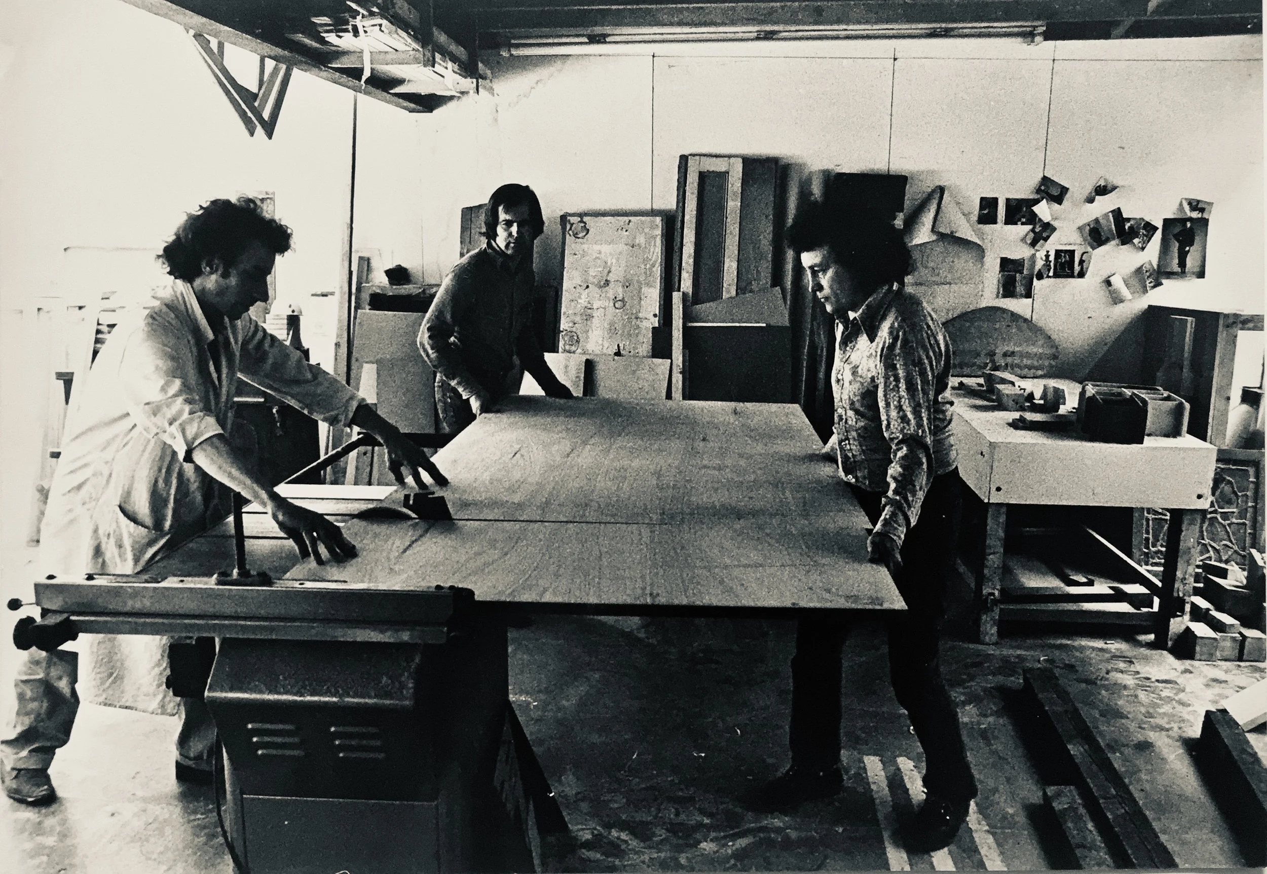 Simon Brint, musician, and Tony Staples, lighting designer, working with Anthony on the first stage of cutting the plywood for the sculptures, 1976-77
