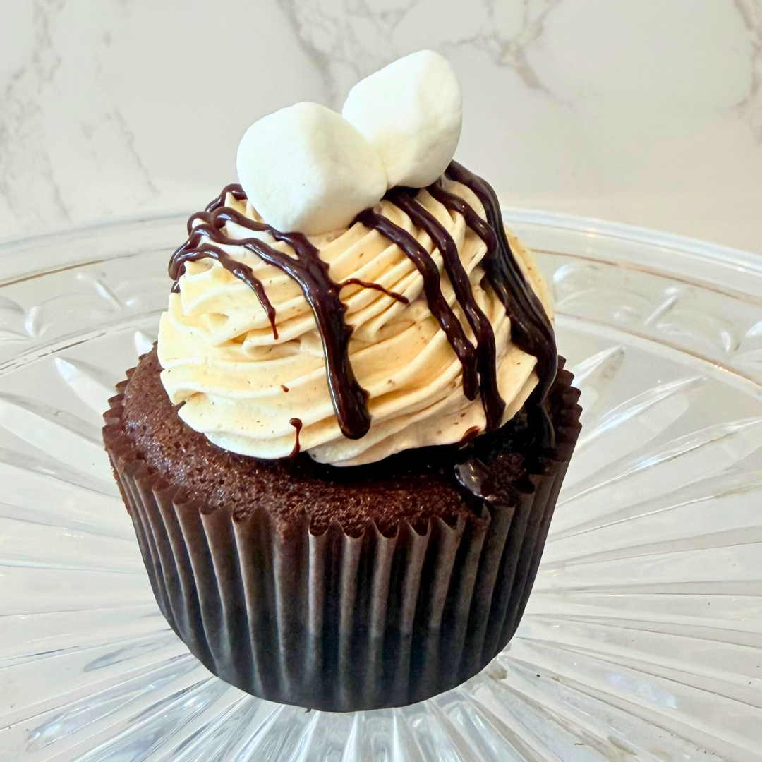 Cupcake with yellow cake, topped with white frosting and red fruit syrup.