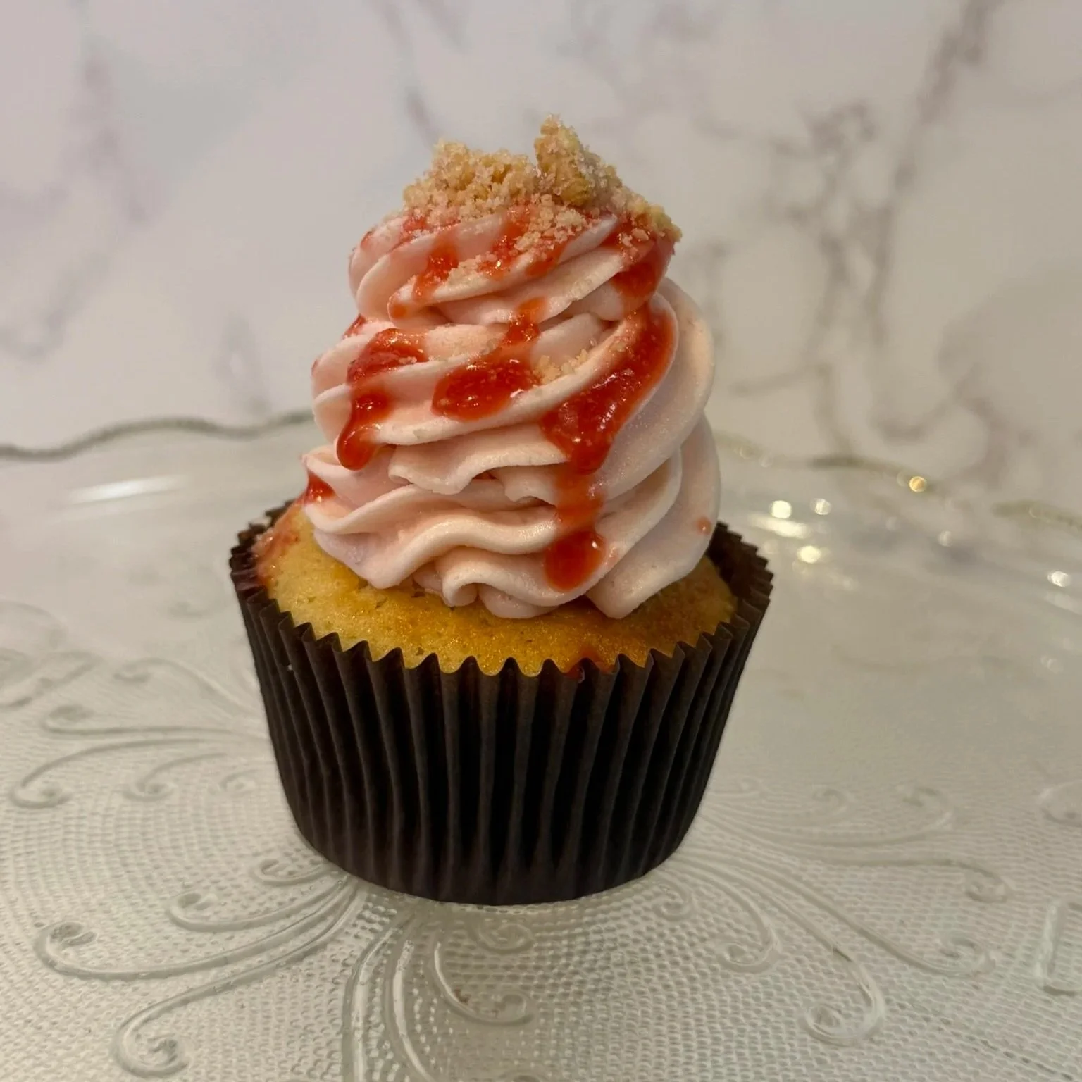 Cupcake with red and pink icinga dark brown cupcake liner