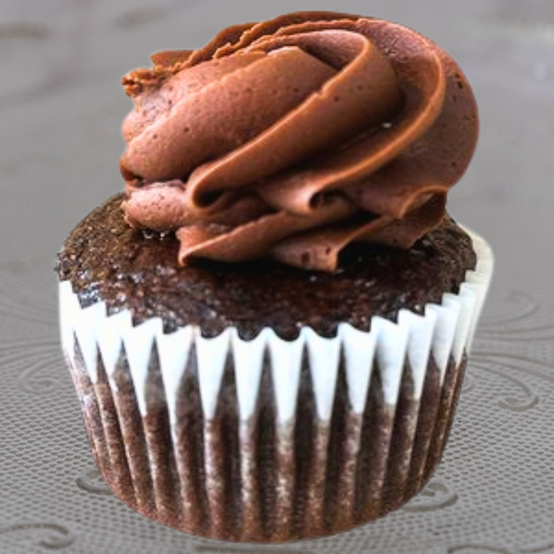 Close-up of a cupcake with brown cake base, topped with white frosting.