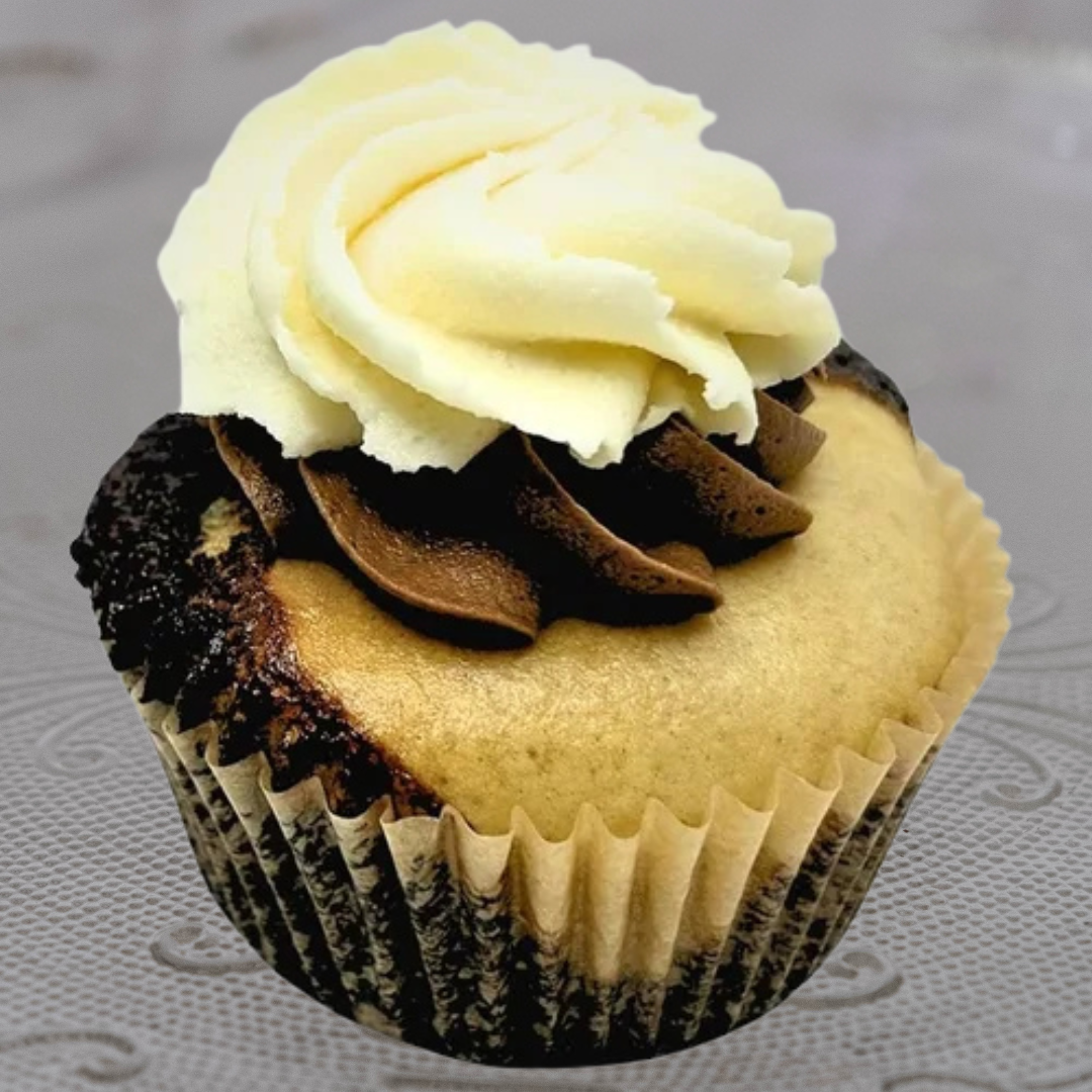 Cupcake with vanilla and chocolate frosting topped with a swirl of white frosting.