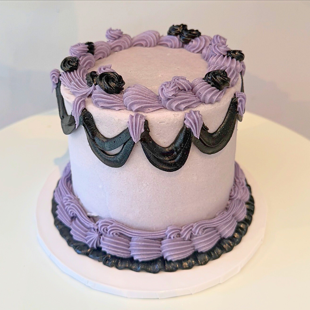 cake with lavender frosting and purple and black accents