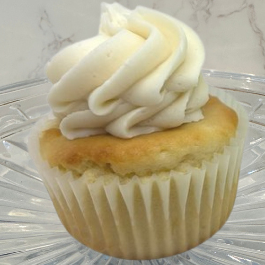 Cupcake with vanilla frosting on top of a cookie.