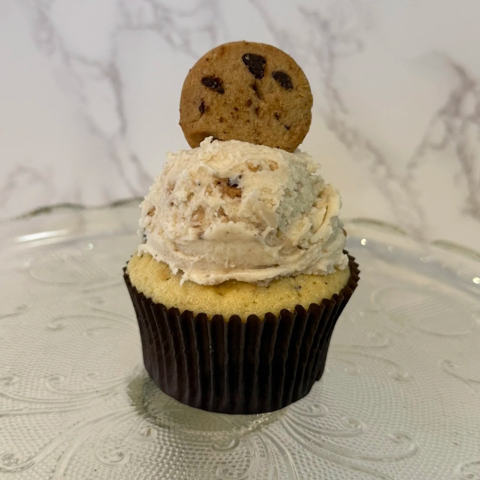 Chocolate cupcake with a swirl of white frosting on top.