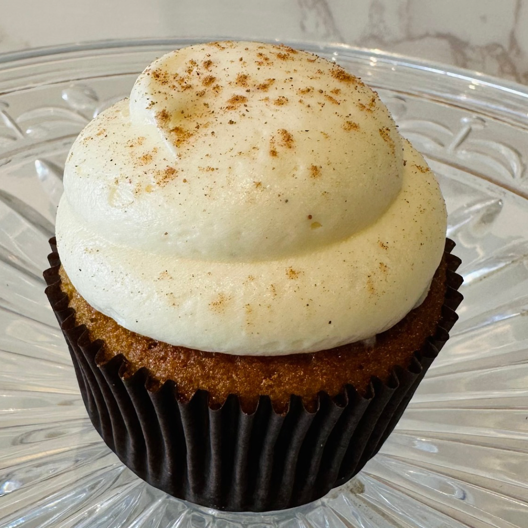 Cupcake with chocolate wrapper, topped with white frosting.