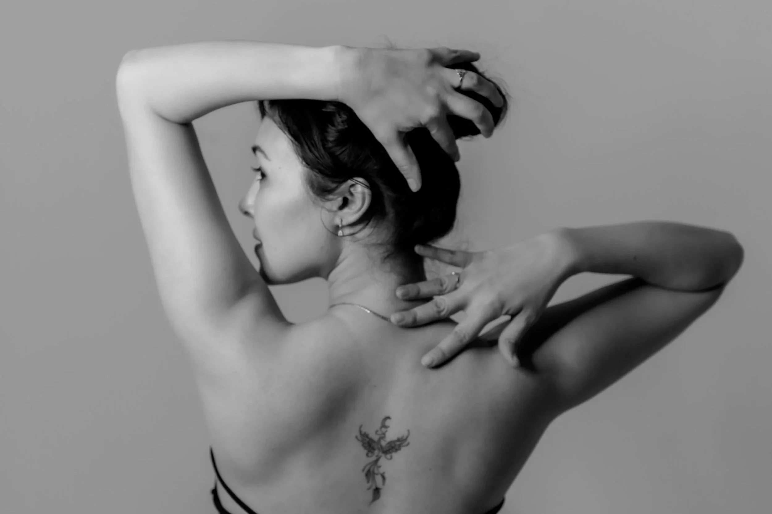 White woman massaging her back and shoulders.