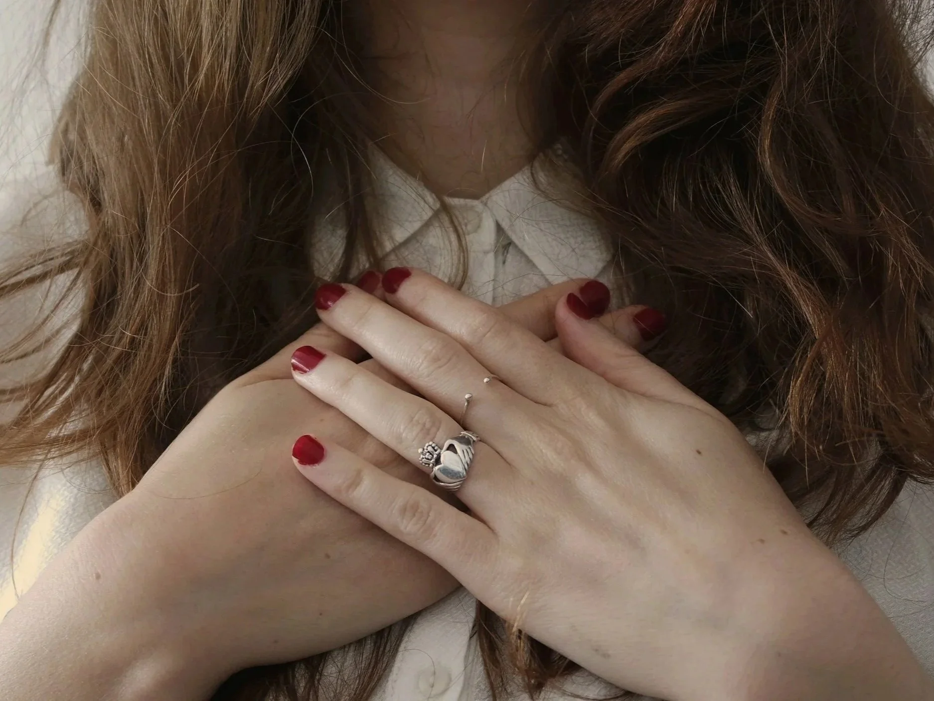 White woman's hands on heart in gratitude