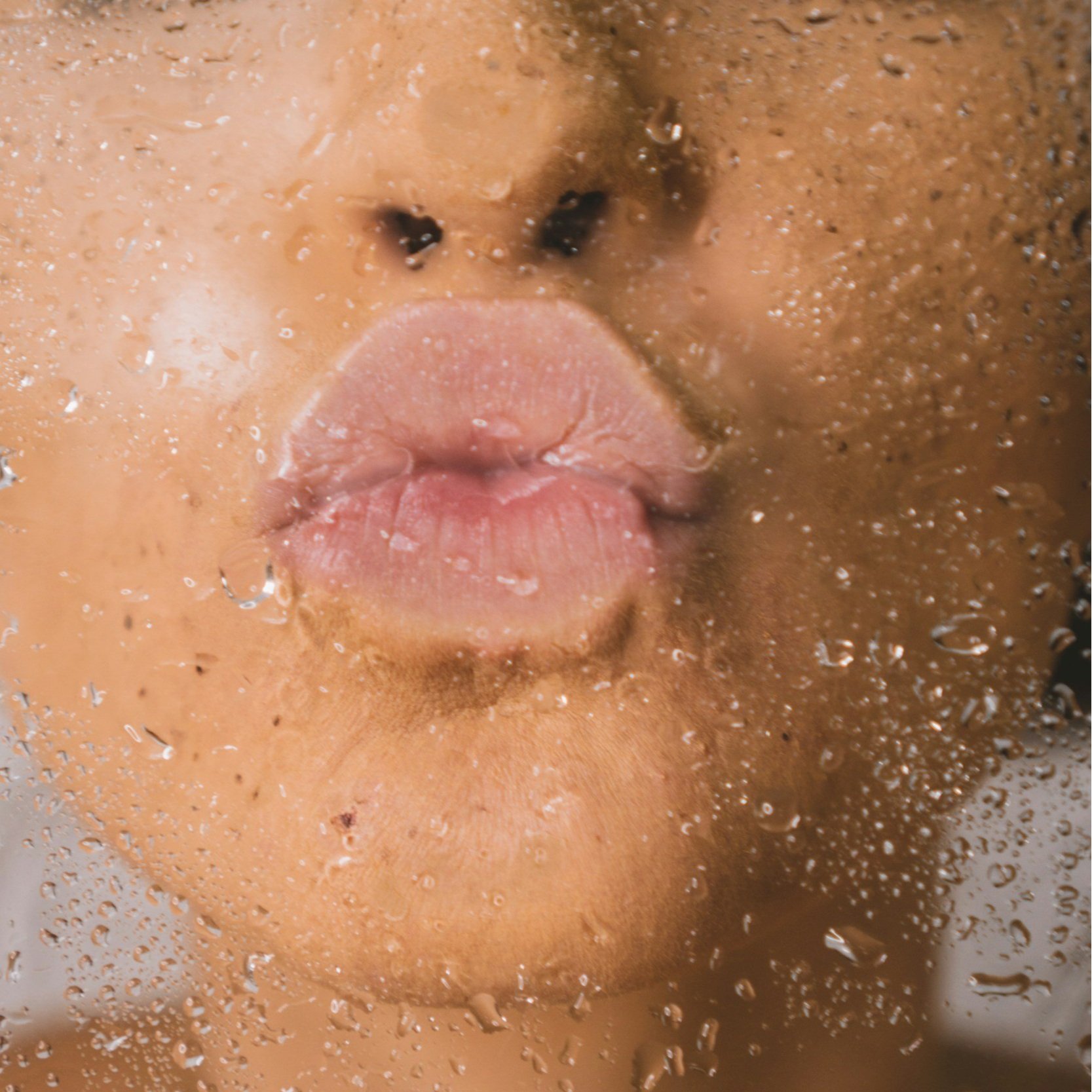 Women's lips kissing wet glass