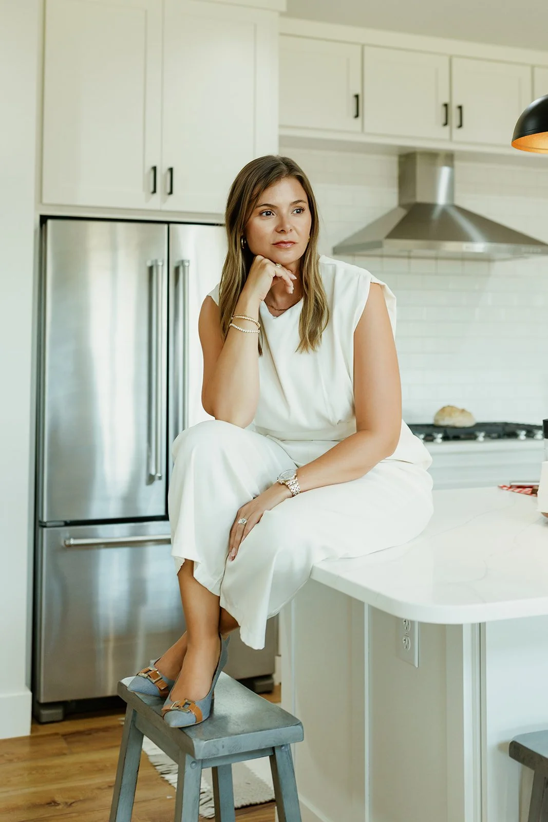 Kerri M. Roberts, keynote speaker & HR Advisor in kitchen, sitting on countertop