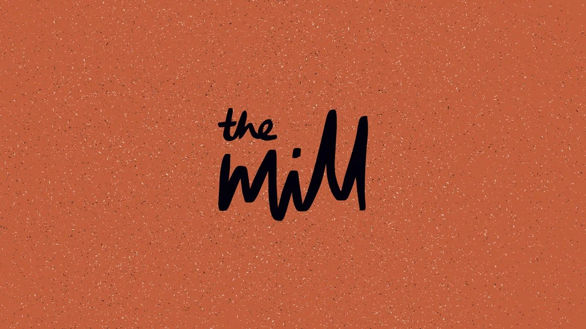 The Mill logo on orange textured background