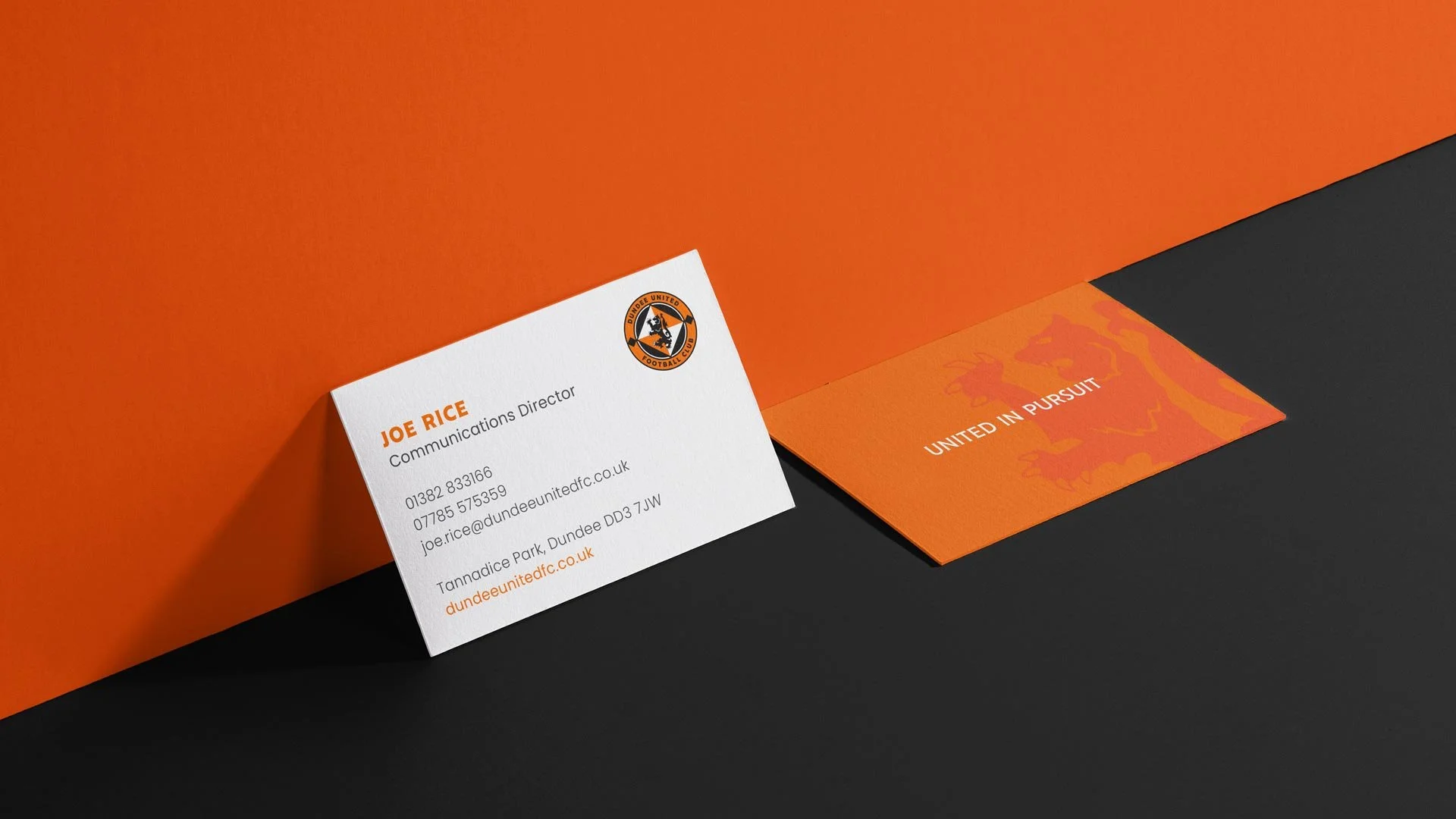 Business card for Joe Rice, Communications Director, with Dundee United Football Club logo, on a black background, with orange and white color scheme, featuring contact details and club slogan 'United in Pursuit'.