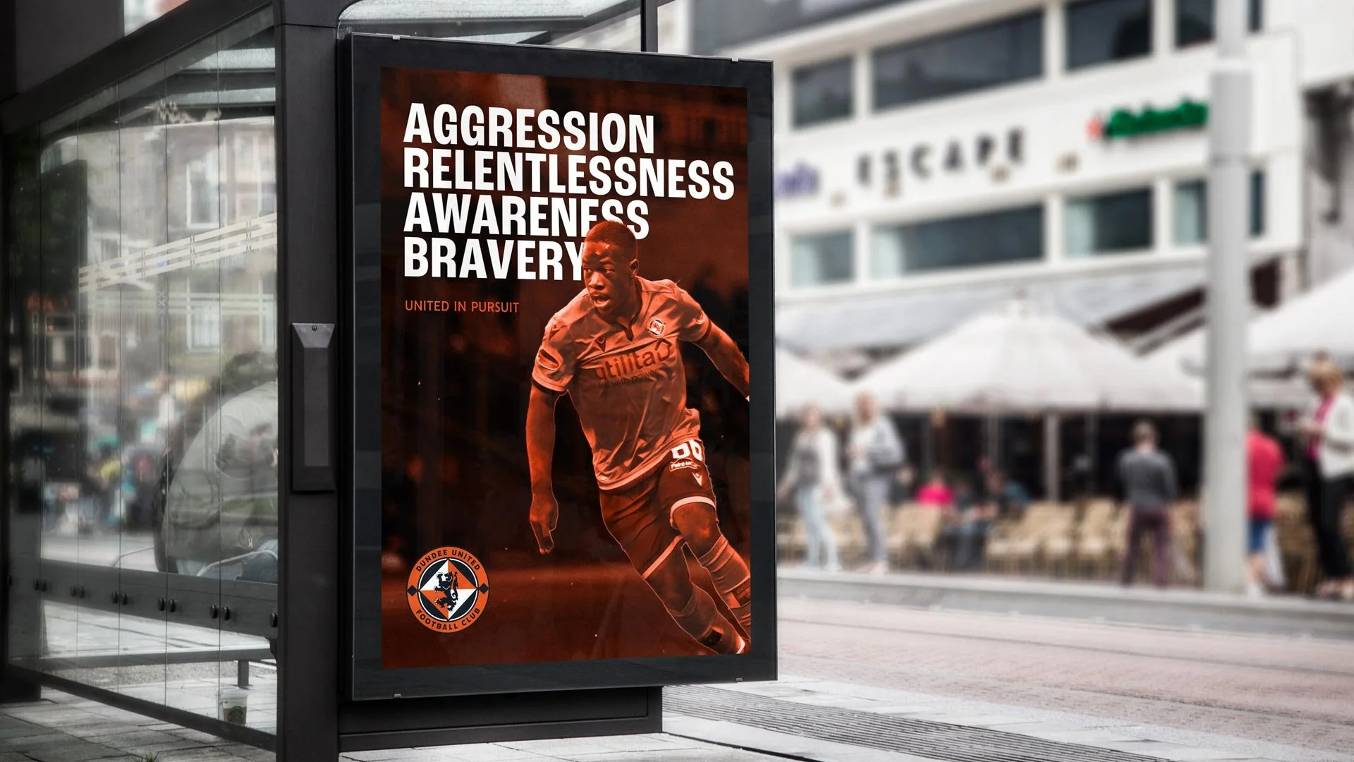 Digital advertisement for Dundee United Football Club featuring a male soccer player in orange uniform running, with words 'Aggression', 'Relentlessness', 'Awareness', 'Bravery' and the club's logo.