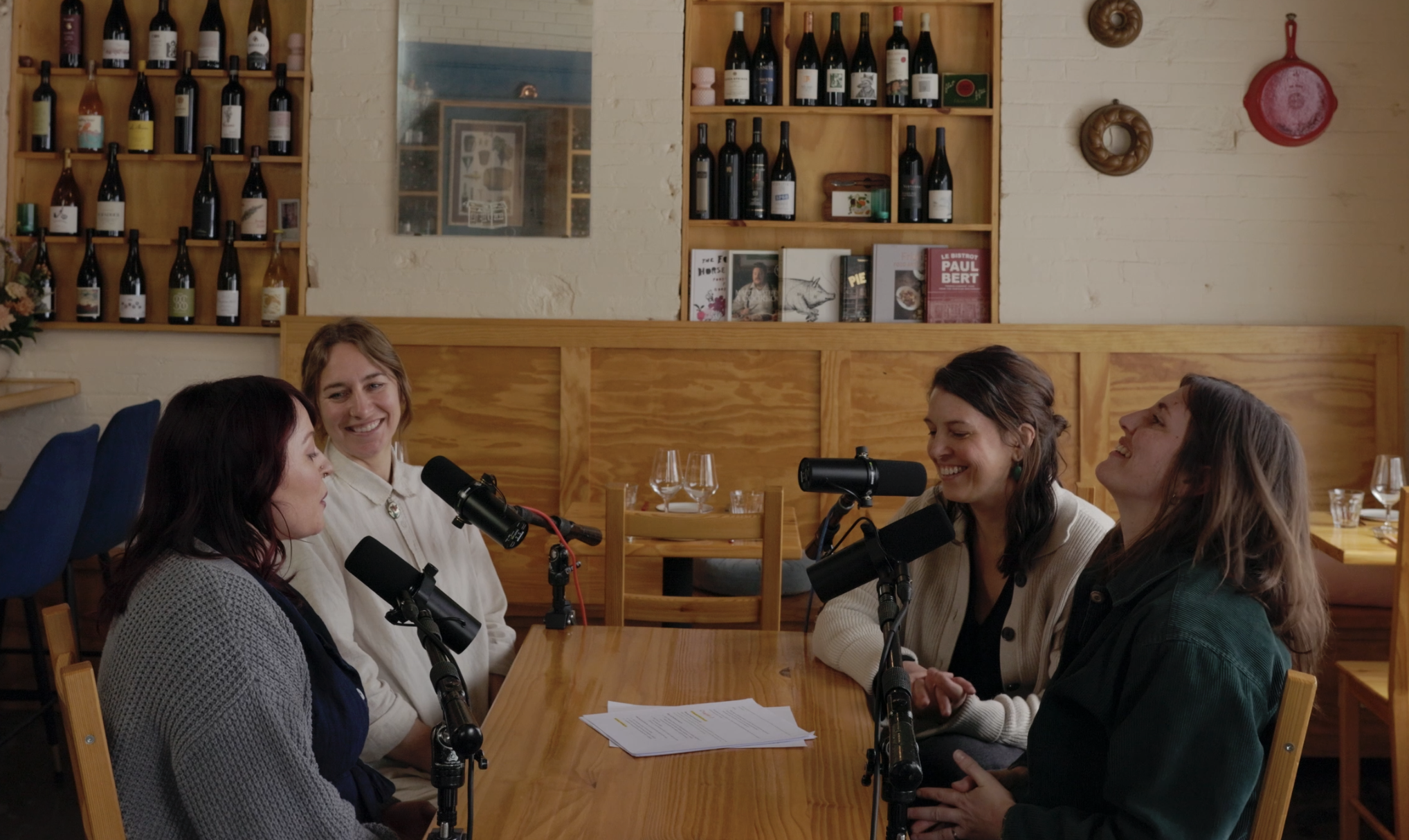 Four marketing experts from Taste the Local Difference laughing at a table at Cafe Mamo with microphones