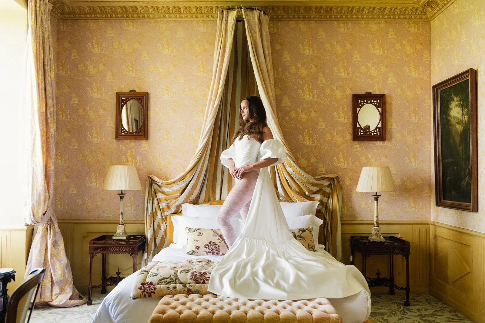 Editorial bridal portrait at Château de Mirambeau (Gironde, France) by Cleya Asulon, destination wedding photographer based in Bordeaux and Cognac — bride in a white off-the-shoulder puff-sleeve gown with sweeping train and blush pink lace tights, st