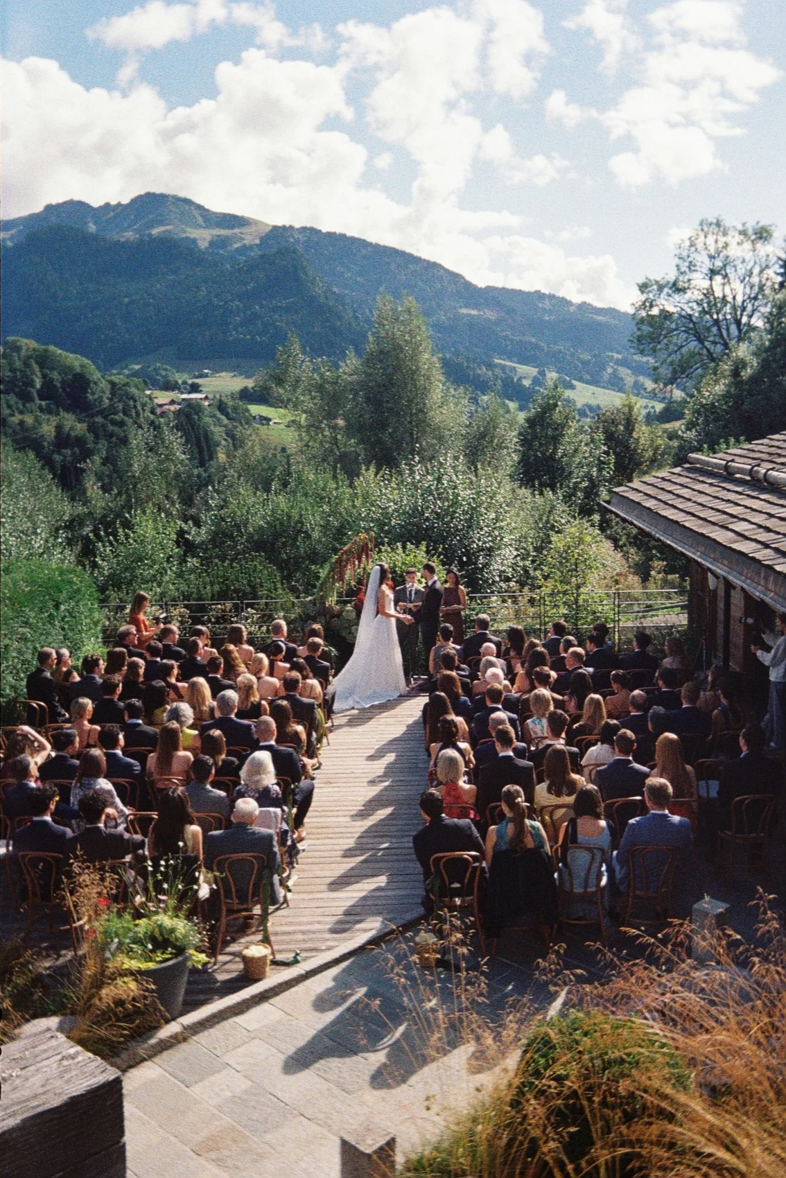 Film photography editorial wedding ceremony at a private chalet in the French Alps near Megève by Cleya Asulon, destination wedding photographer for Megève, Mont-Blanc and the Haute-Savoie region — wide overhead view of the bride and groom exchanging