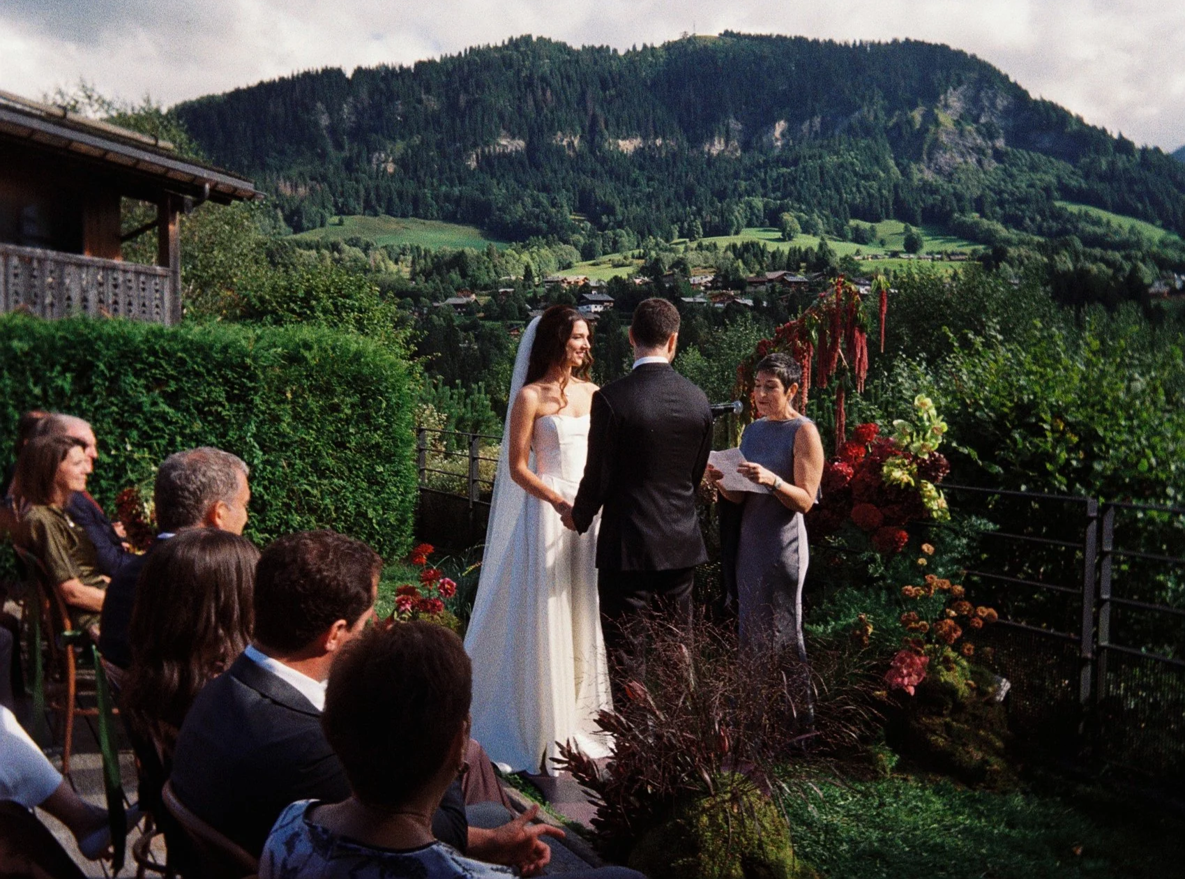 Film photography editorial wedding ceremony moment at a private chalet in the French Alps near Megève by Cleya Asulon, destination wedding photographer for Megève, Mont-Blanc and the Haute-Savoie region — bride in a strapless white satin gown with sw