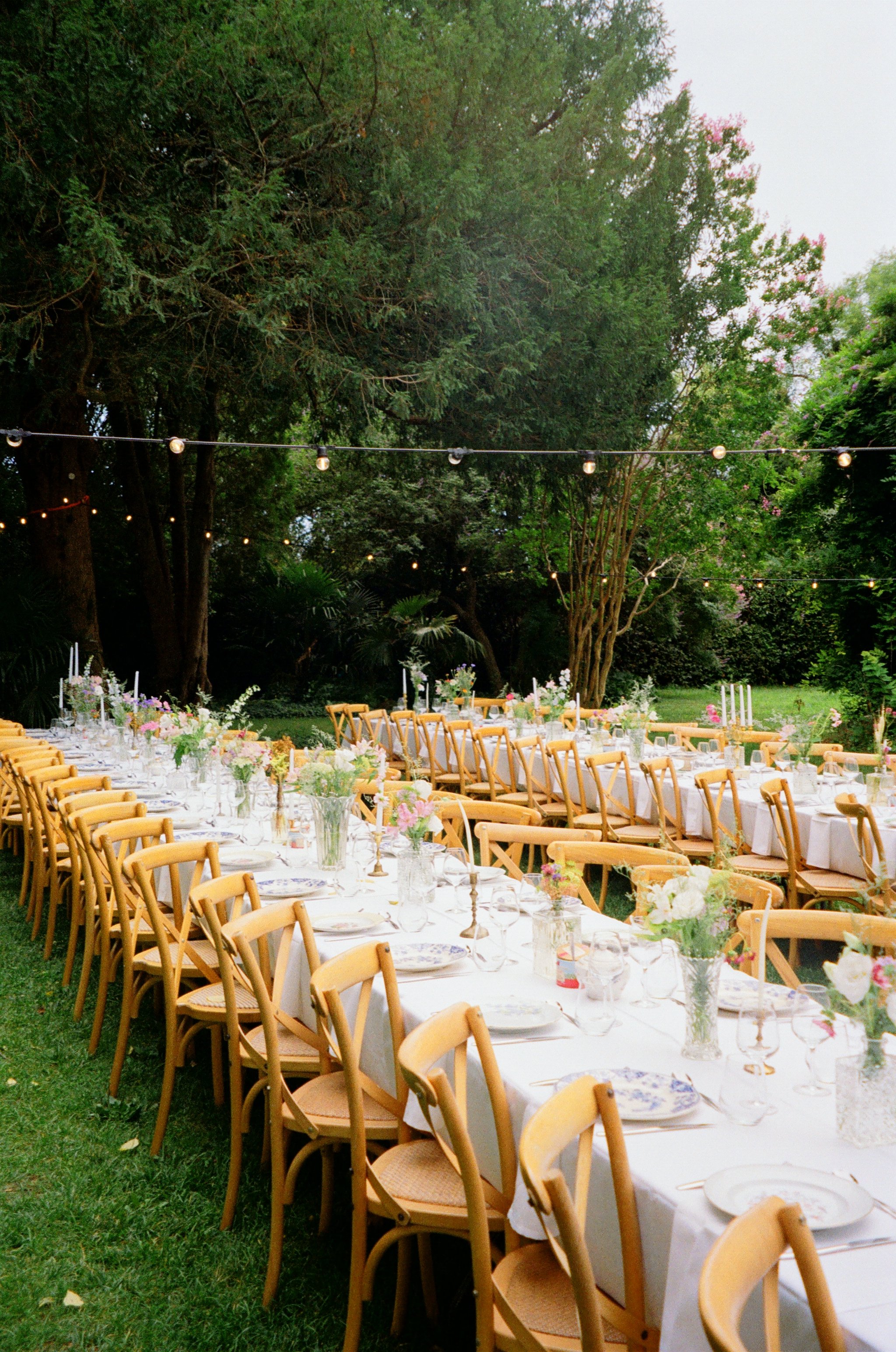 Film photography editorial wedding reception setup at Jardins de Campagne, a private villa near Nîmes in the South of France by Cleya Asulon, destination wedding photographer for Nîmes, Provence and the Occitanie region — long banquet tables dressed 