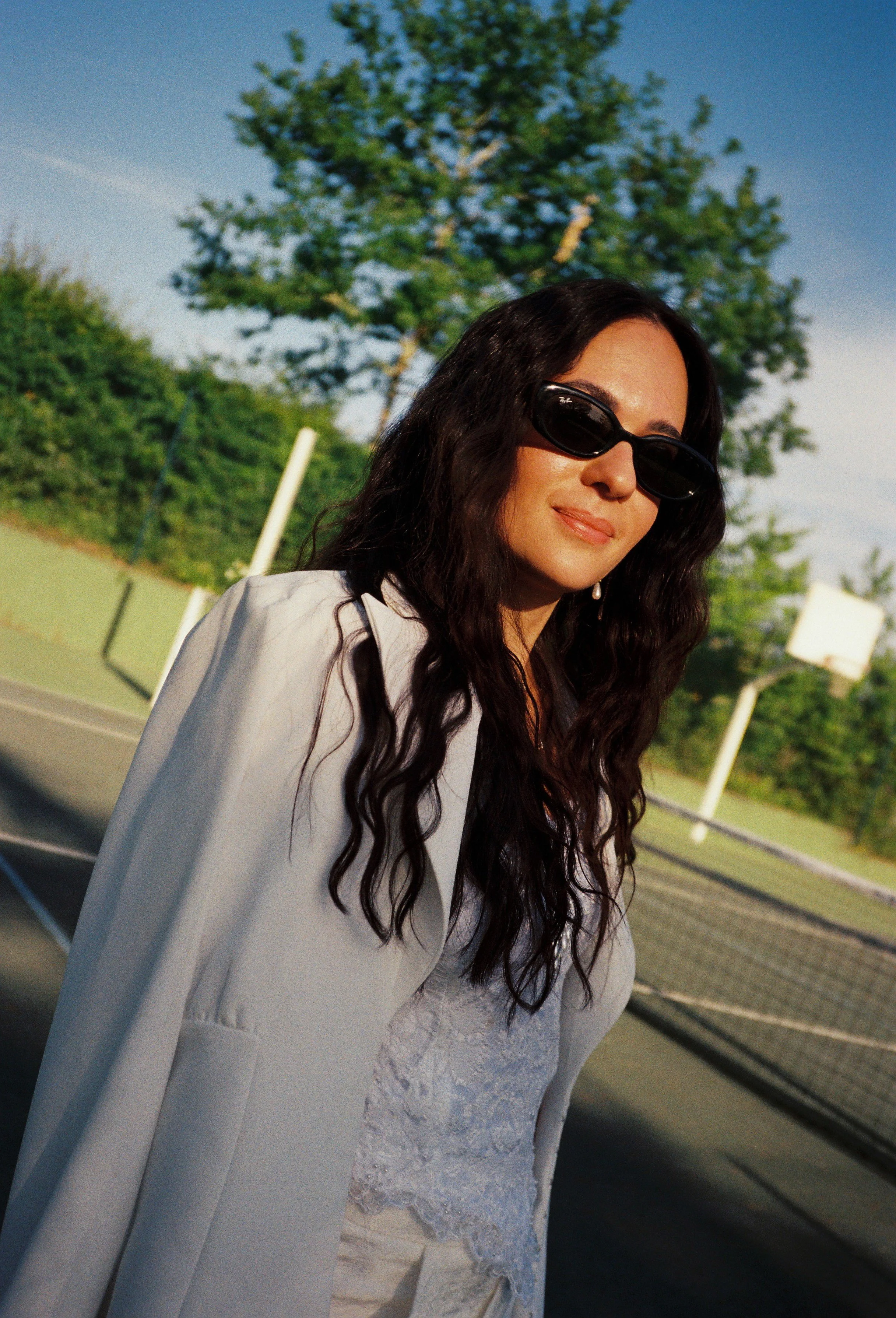 Film photography wedding welcome event portrait at Château Gassies near Bordeaux, France by Cleya Asulon, destination wedding photographer for Bordeaux and the Gironde region — bride styled in a cool effortless mood, wearing a delicate ivory lace dre