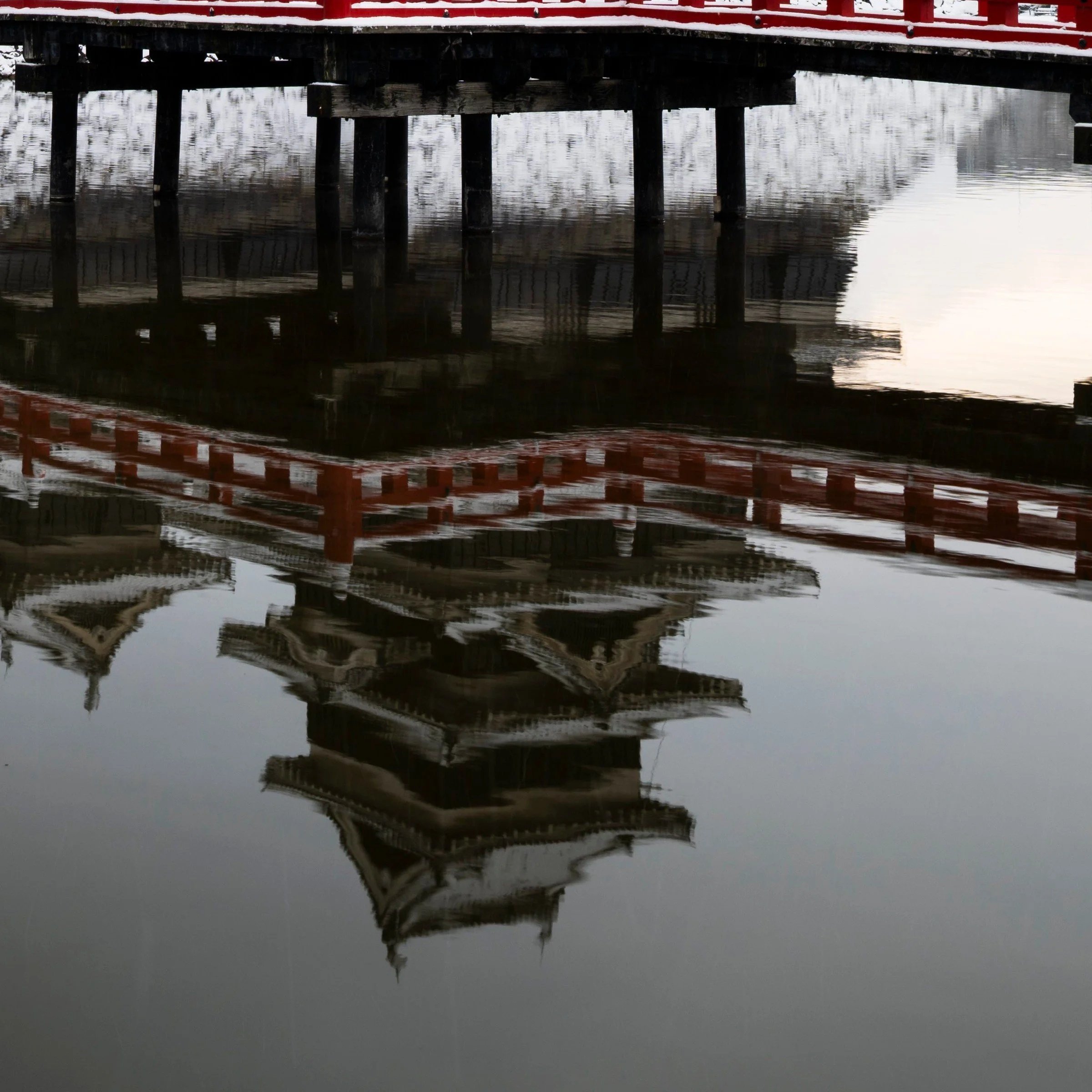 Close-up of Matsumoto Castle's reflection in the moat beside the red bridge, Nagano Prefecture, Japan