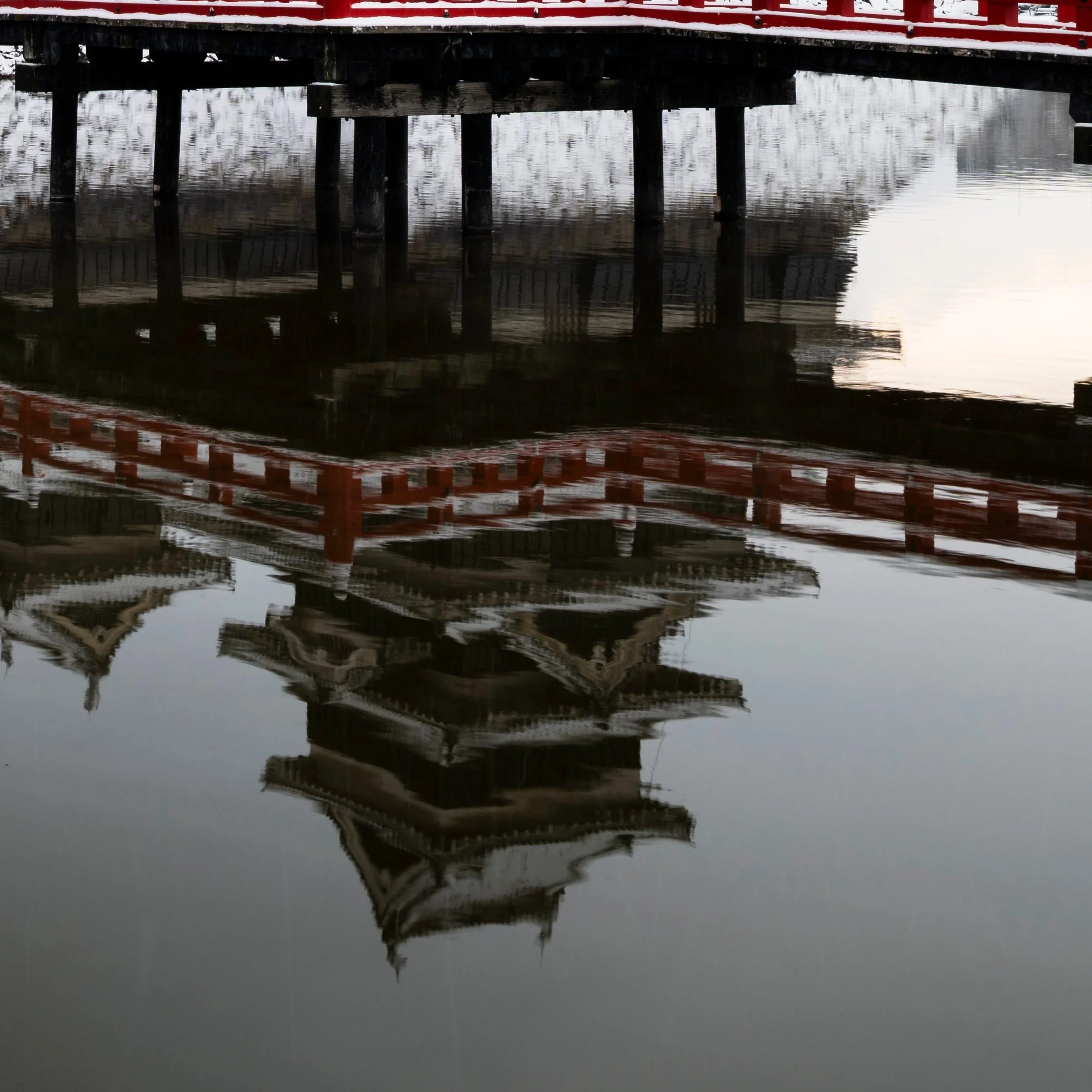 Close-up of Matsumoto Castle's reflection in the moat beside the red bridge, Nagano Prefecture, Japan