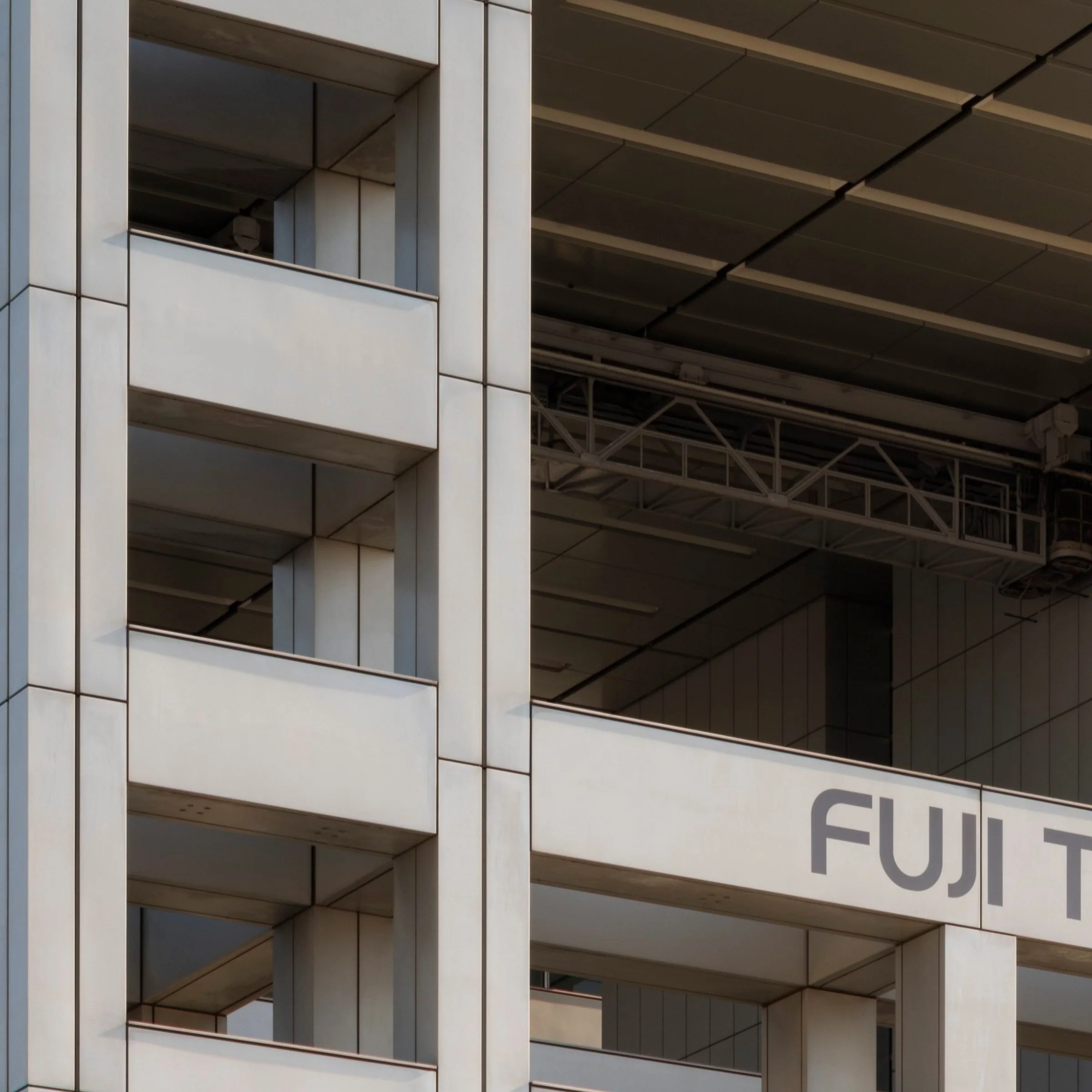 Close-up of the FUJI TELEVISION signage and concrete grid facade, Fuji TV Headquarters, Odaiba, Tokyo, Japan